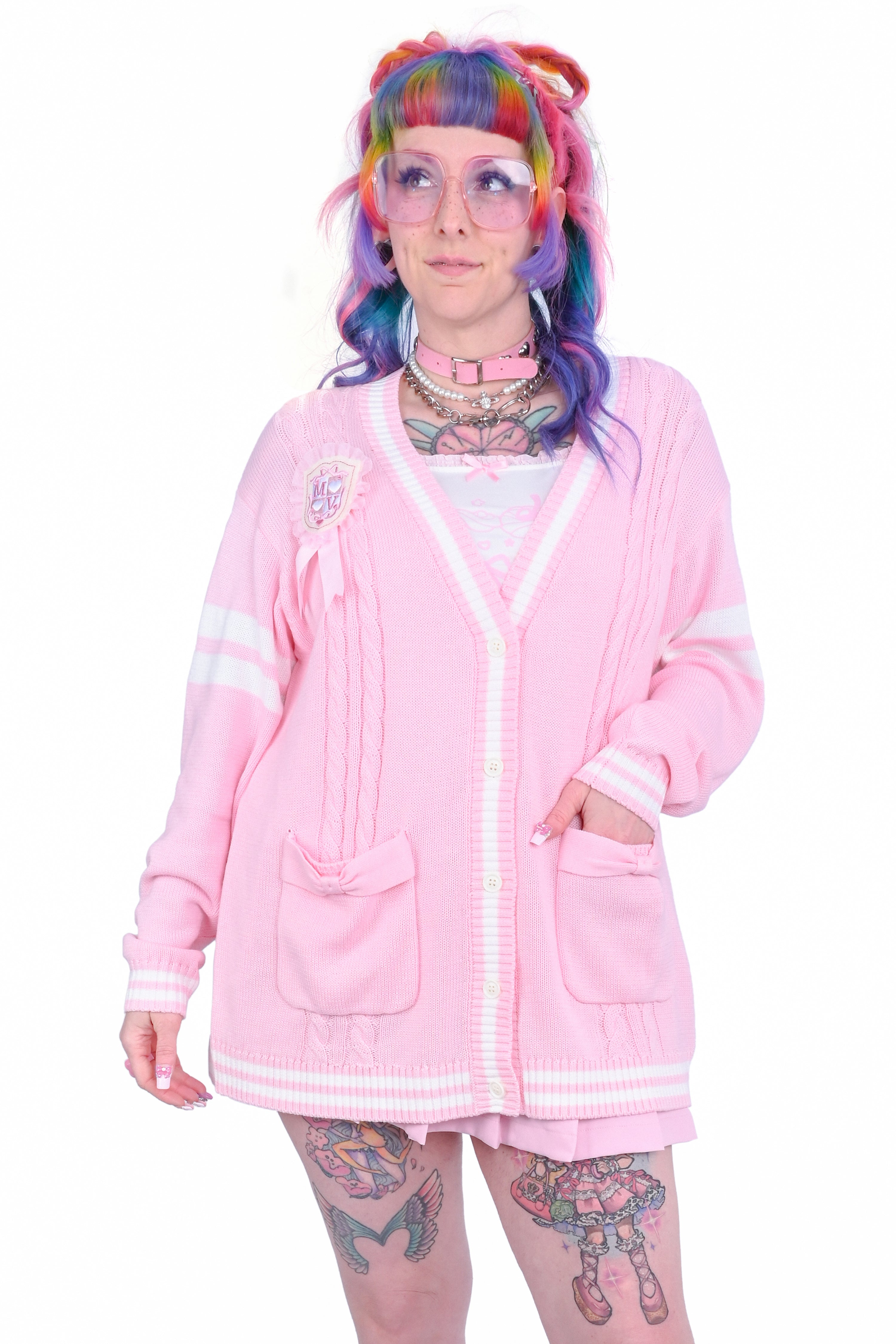 A person wearing a pink cardigan with white trim