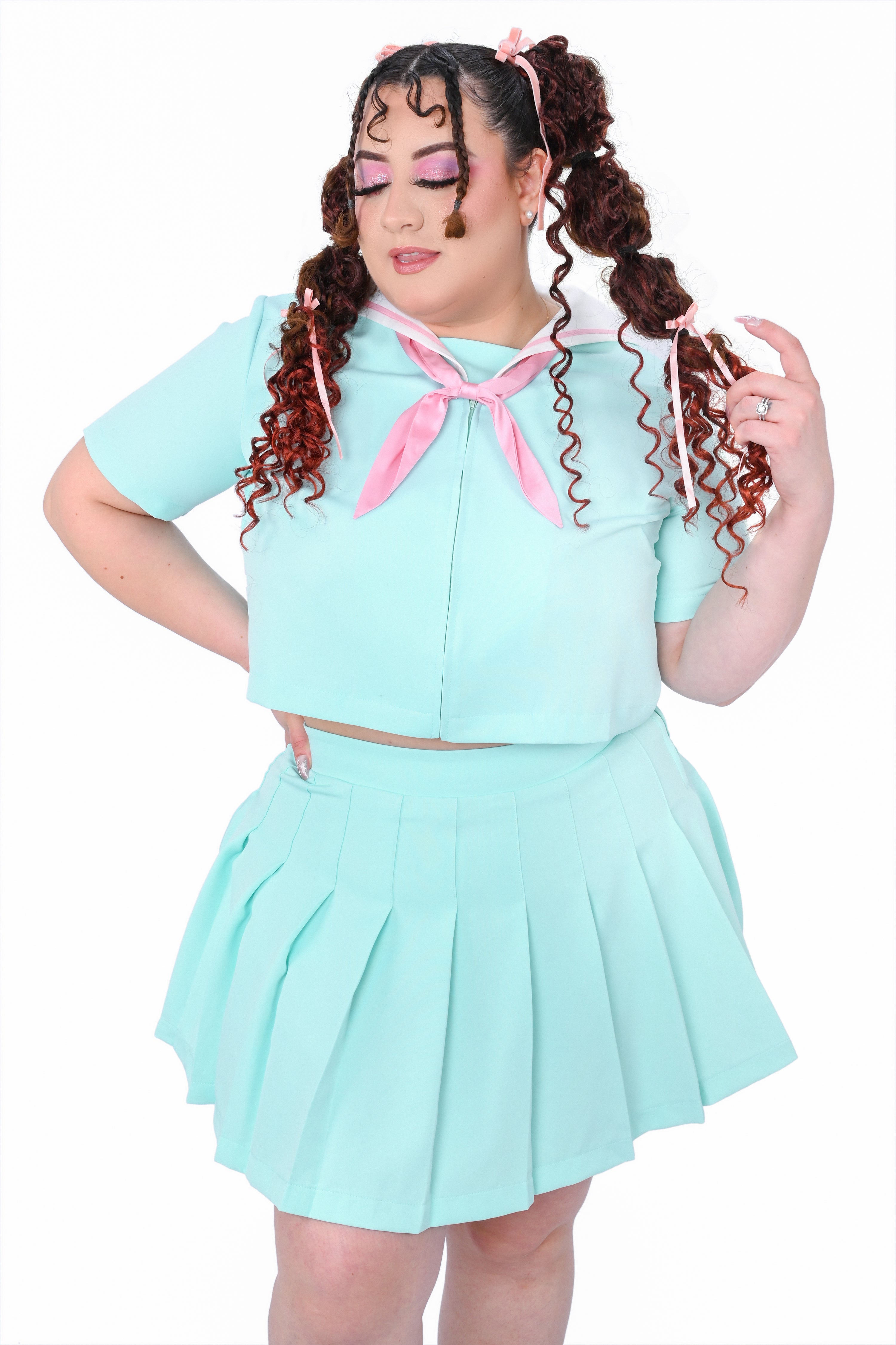 A model wearing a mint sailor collar with a pink bow and a matching pleated skirt