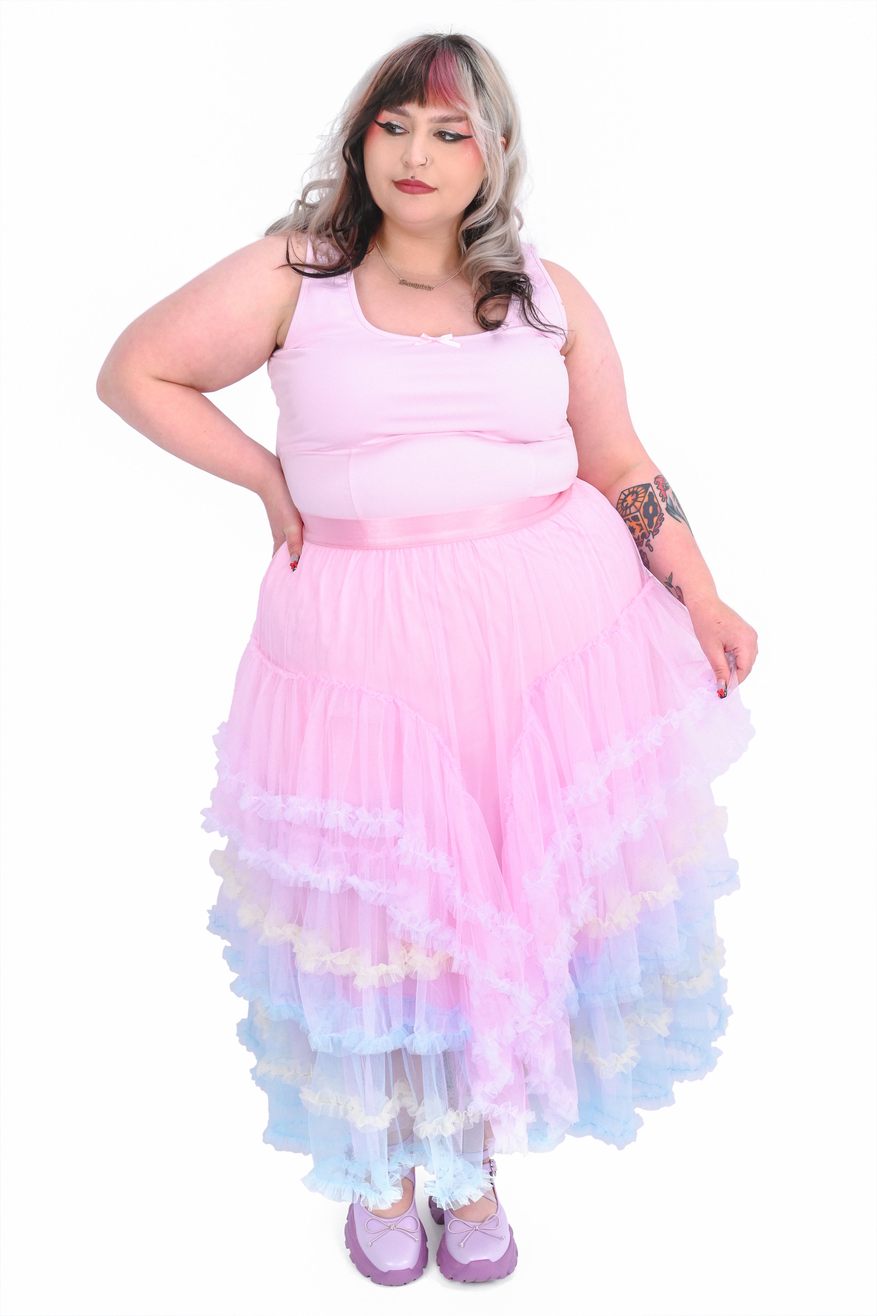 A person wearing a ruffled tiered maxi skirt with multicolored layers of pastel tulle