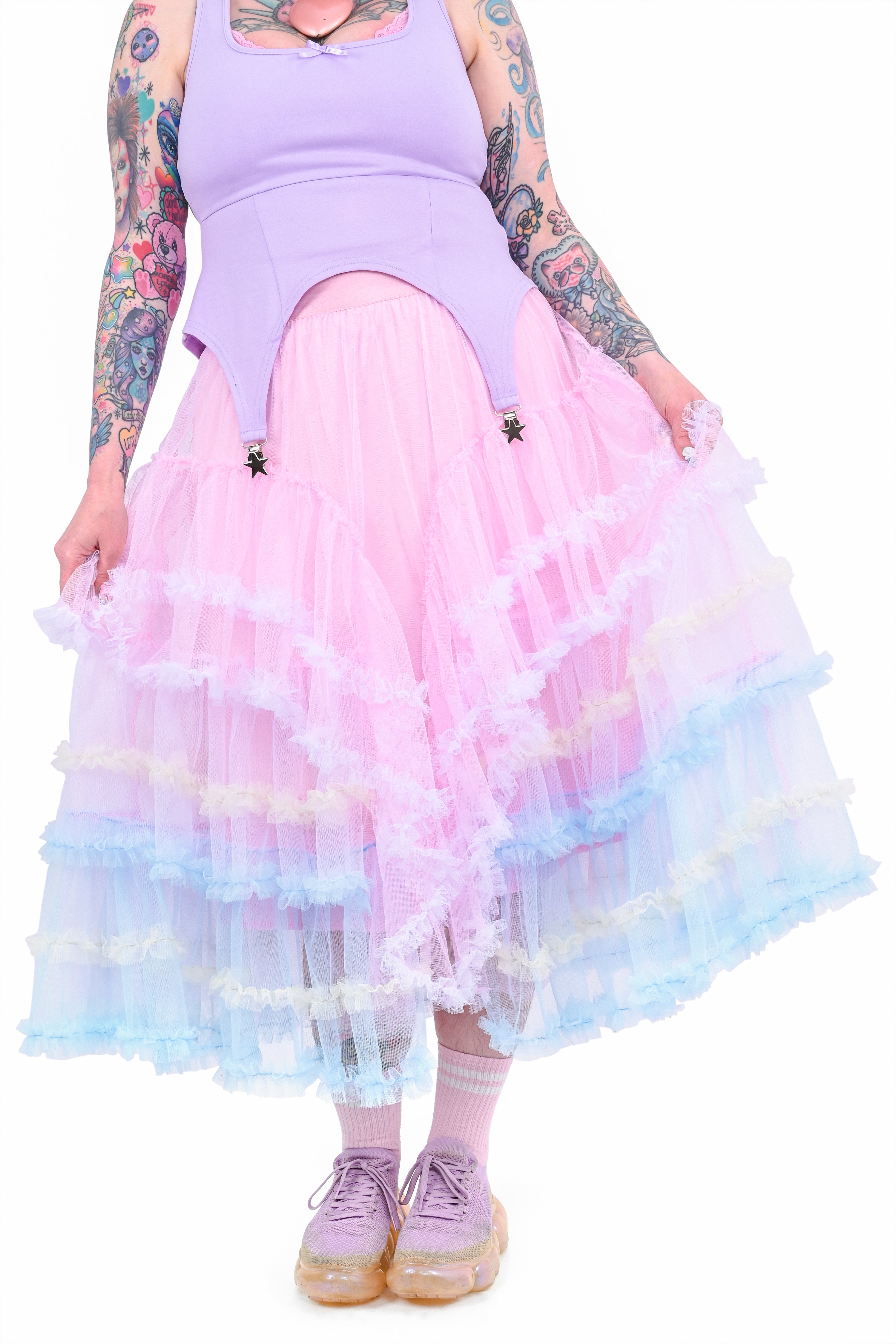 A person wearing a ruffled tiered maxi skirt with multicolored layers of pastel tulle