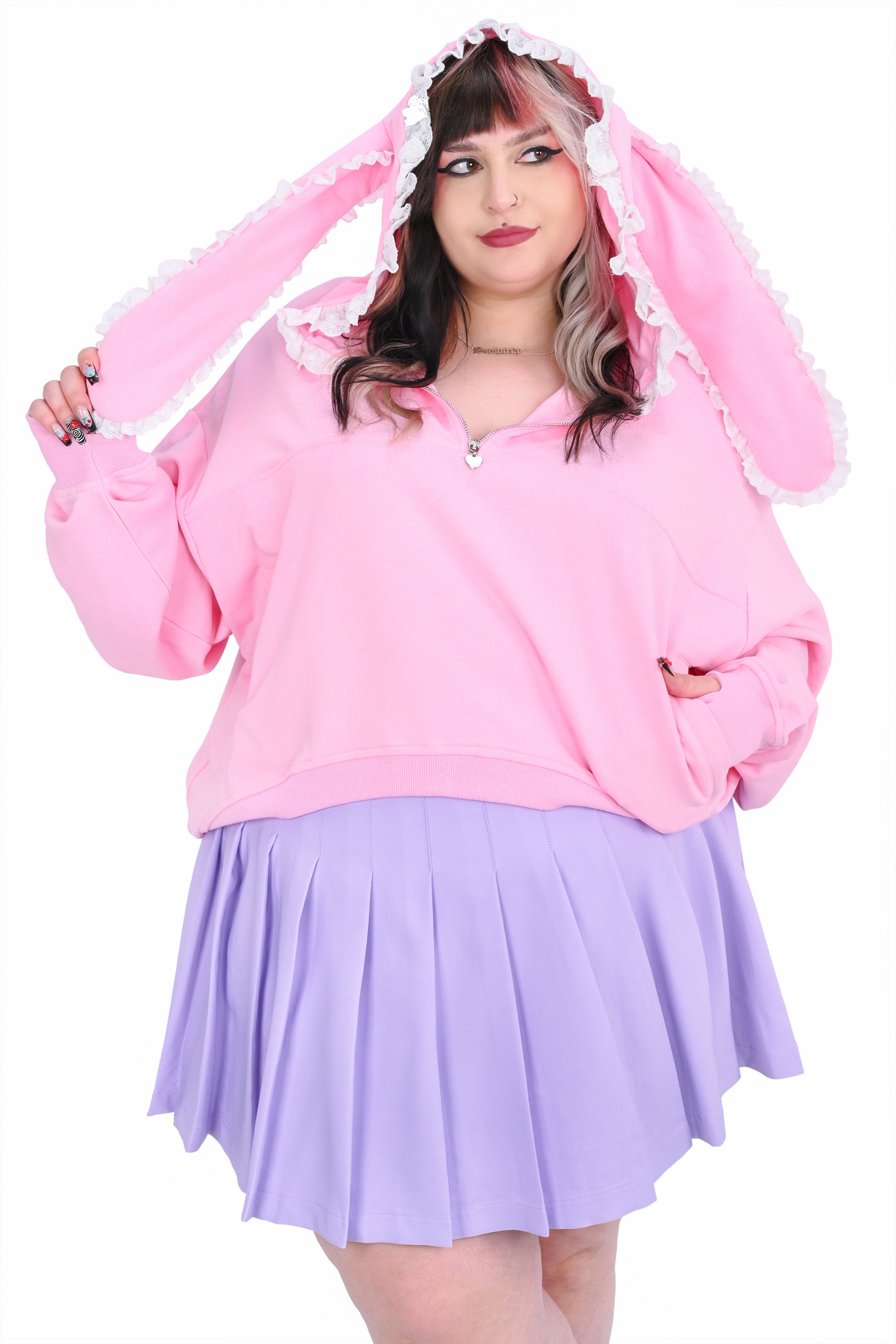 A person wearing a relaxed fit pink hoodie with pink bunny ears and lace and a lavender skirt