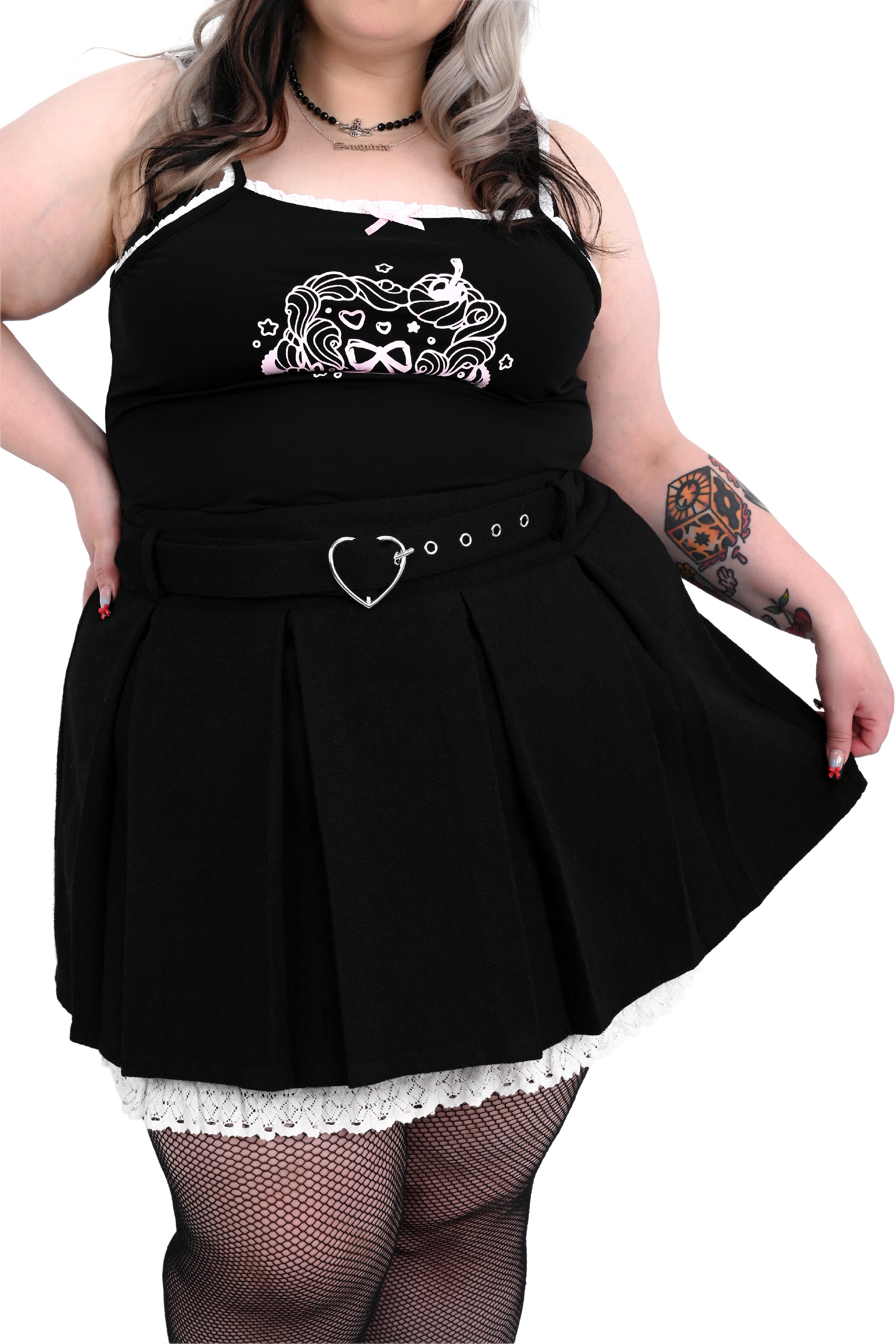 Person wearing a black skirt with a heart-shaped belt on a white background