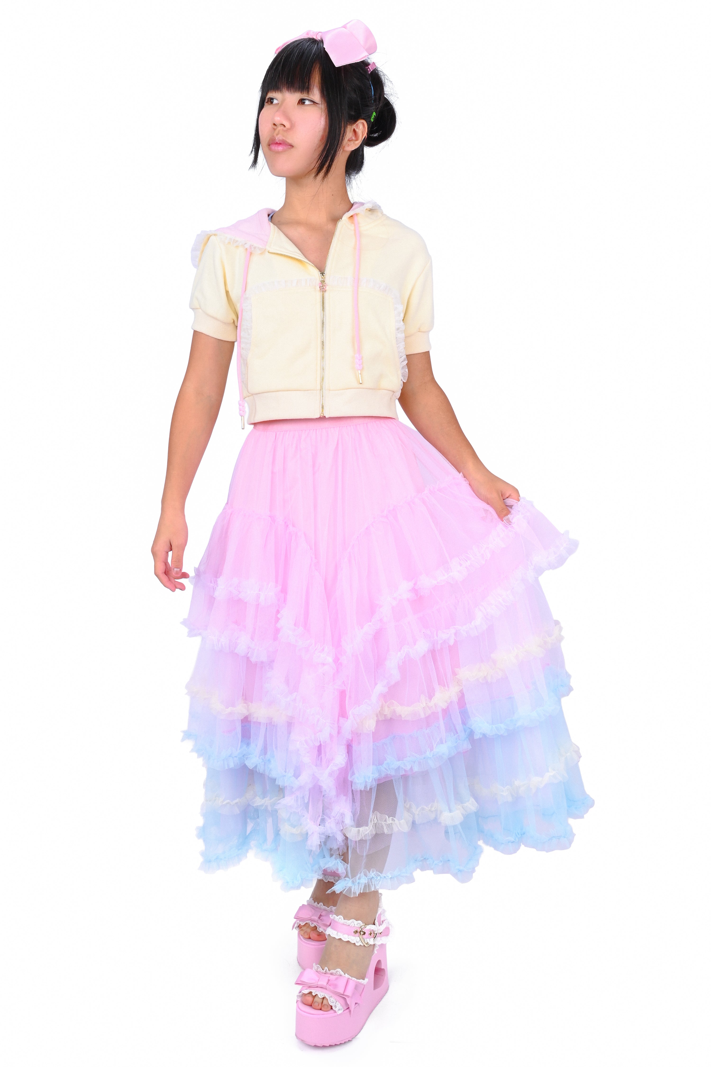 A person wearing a ruffled tiered maxi skirt with multicolored layers of pastel tulle