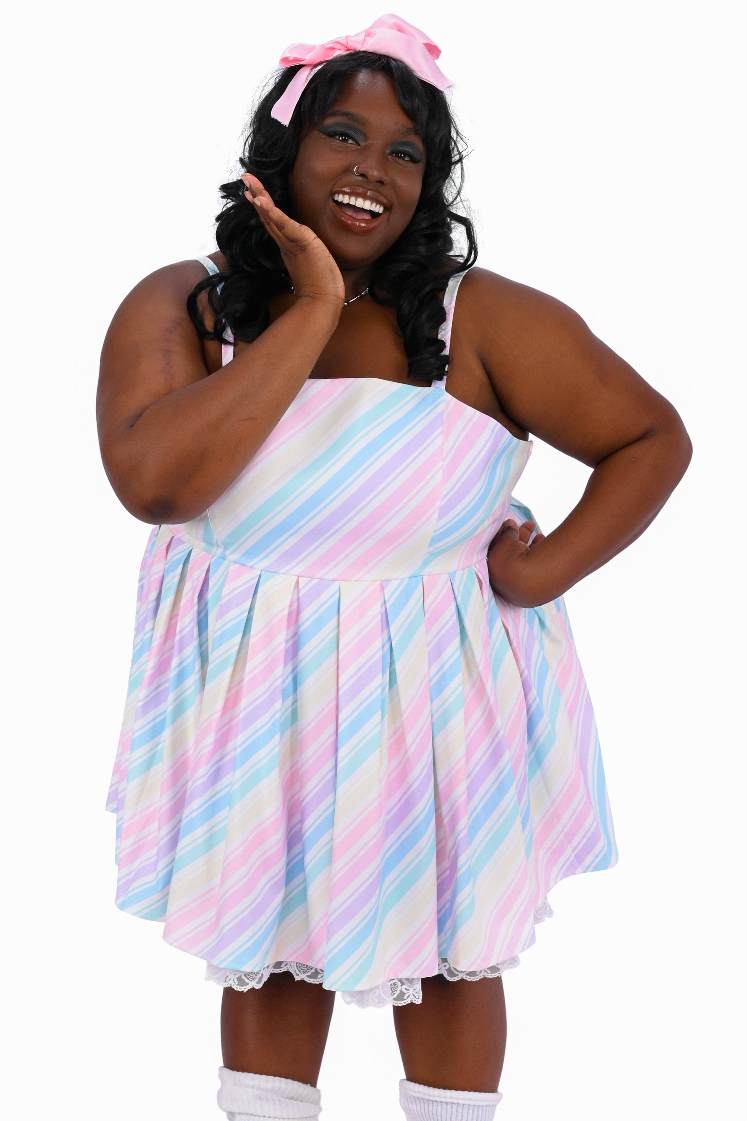 Person wearing a pastel striped dress with a white background
