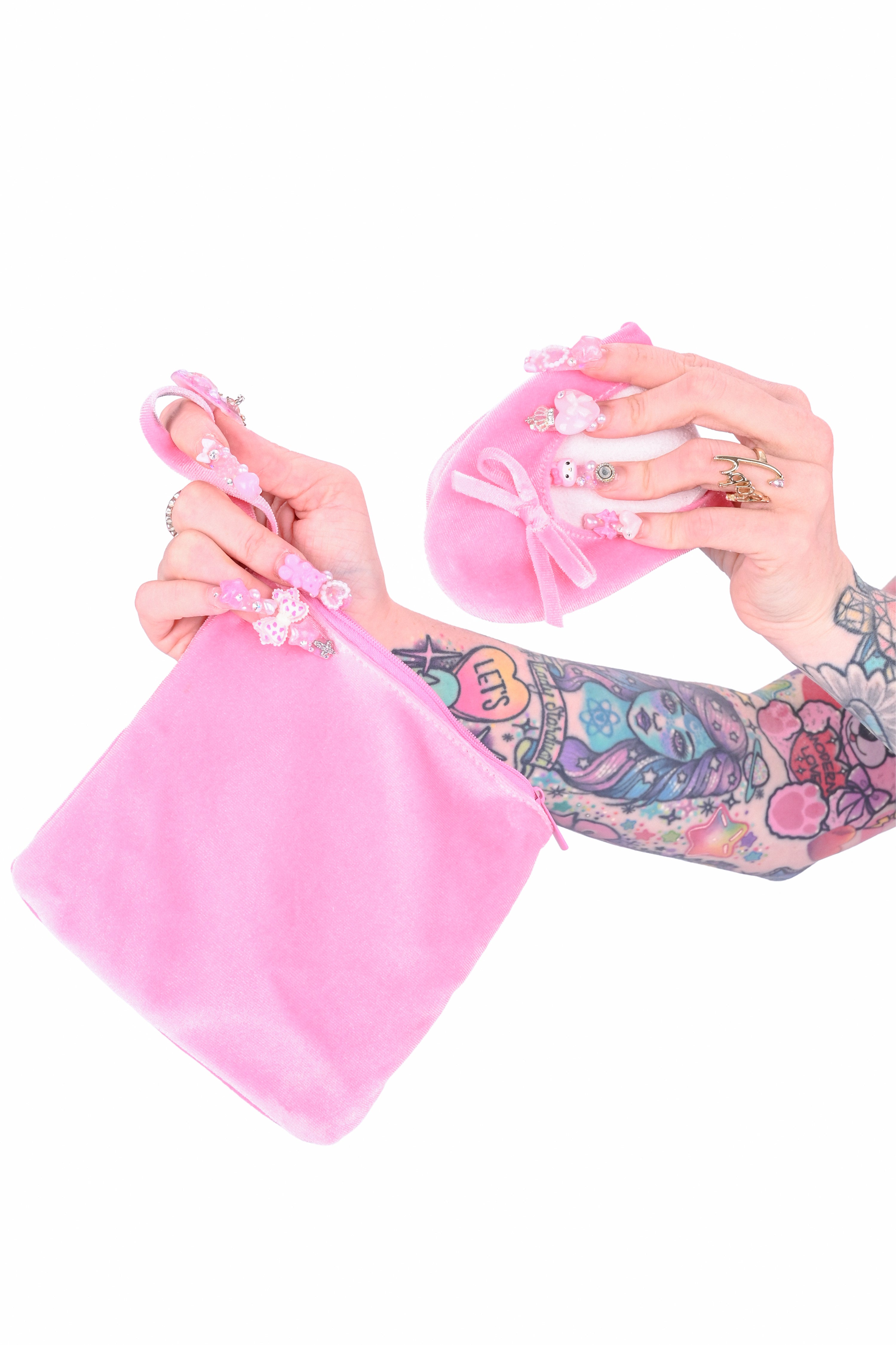 A person holding a pair of velvet flats and a matching velvet zipper carrying pouch