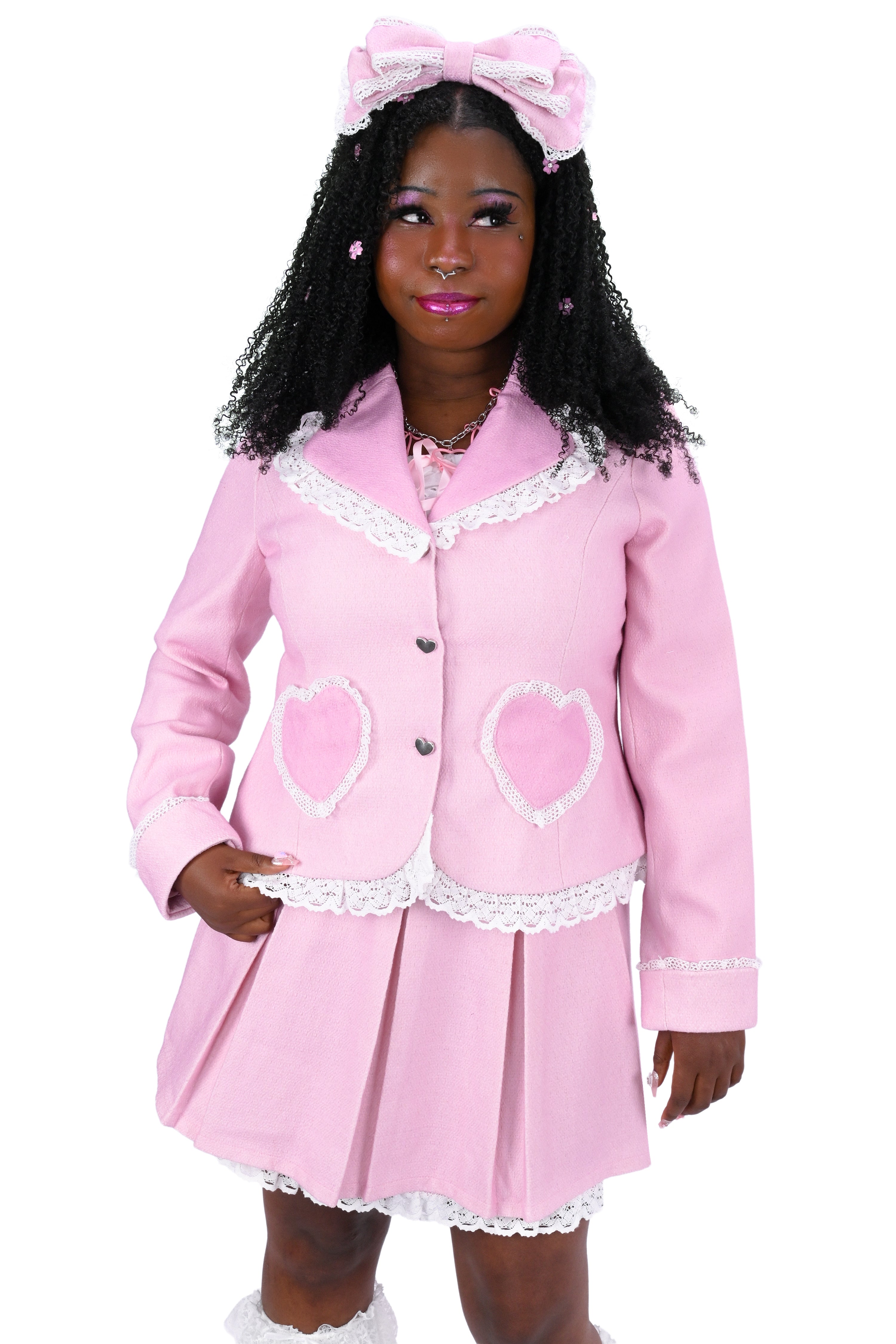 Person wearing a pink heart pocket blazer and matching skirt on a white background