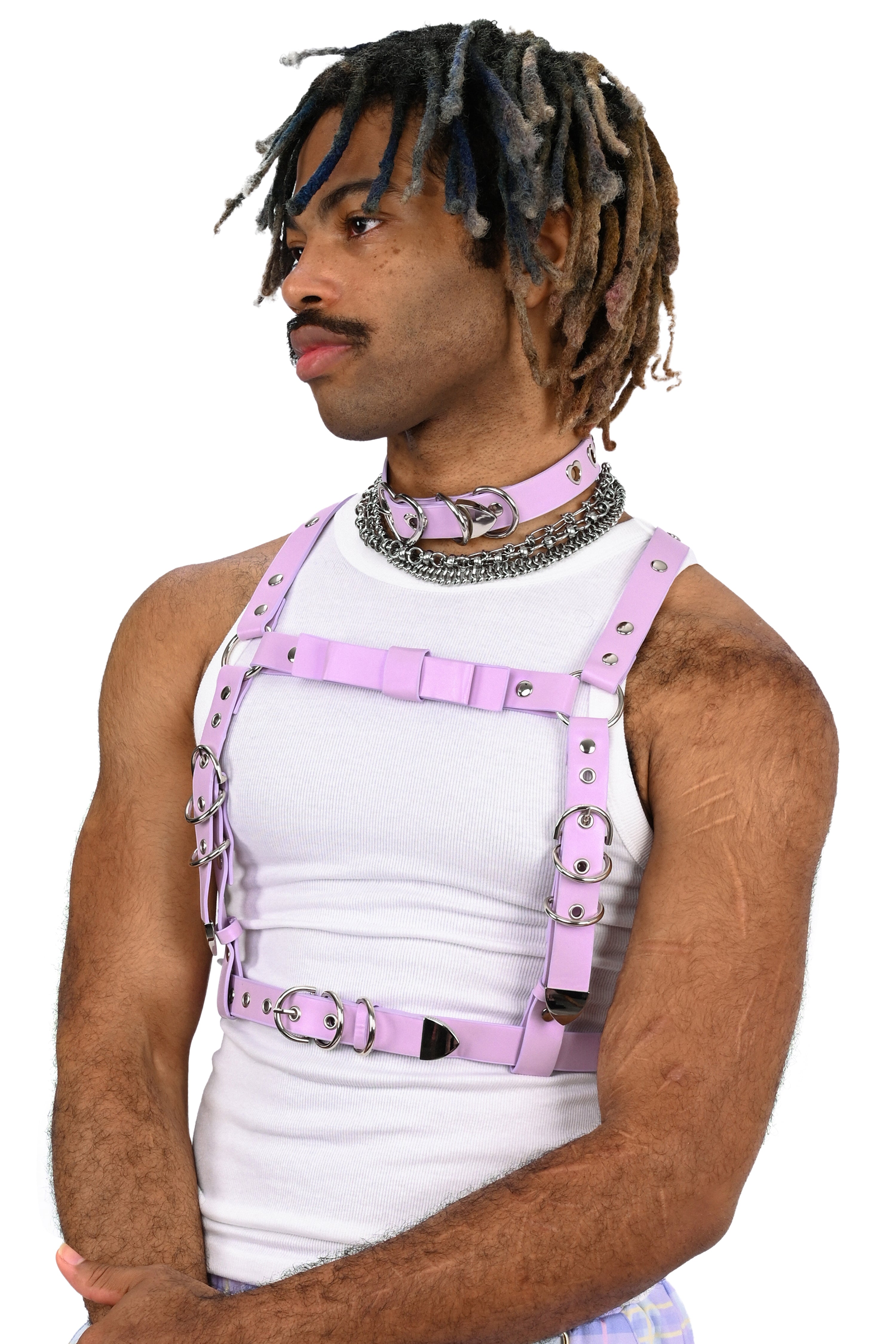 Person wearing a pink leather harness over a white tank top on a white background
