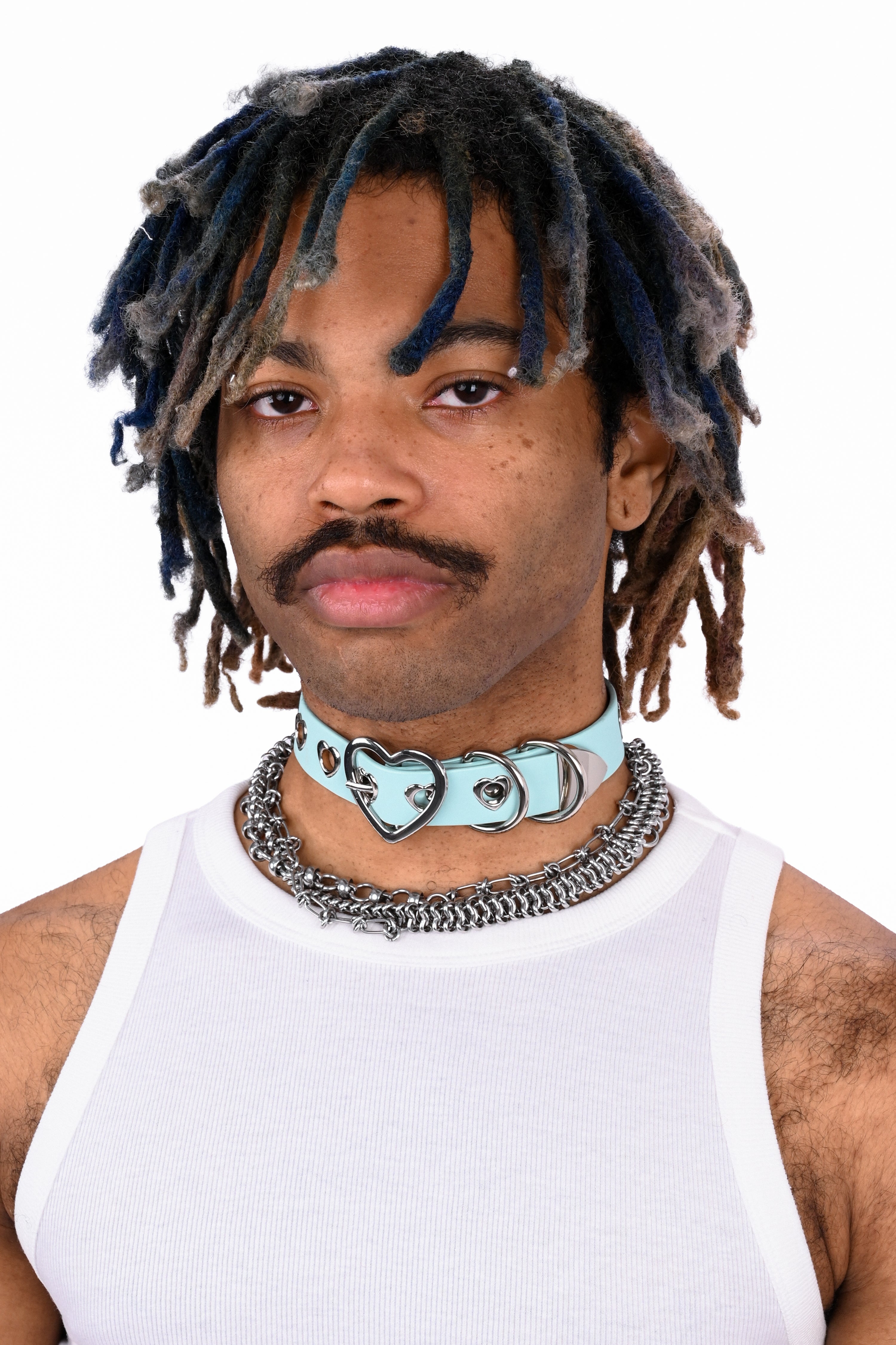 Person wearing a white tank top and multiple necklaces on a white background