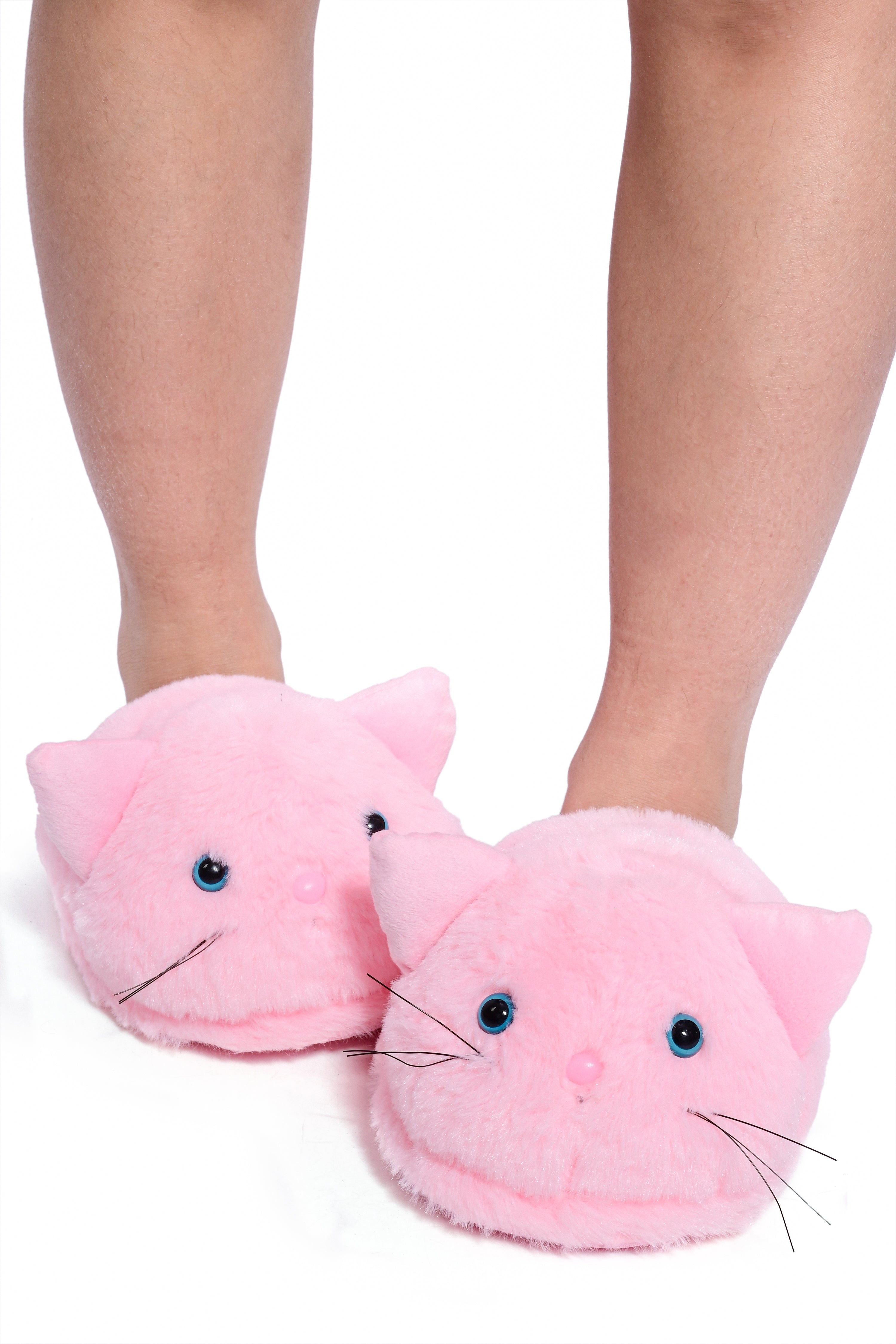 A model wearing a pair of pink fluffy slippers designed to look like cats