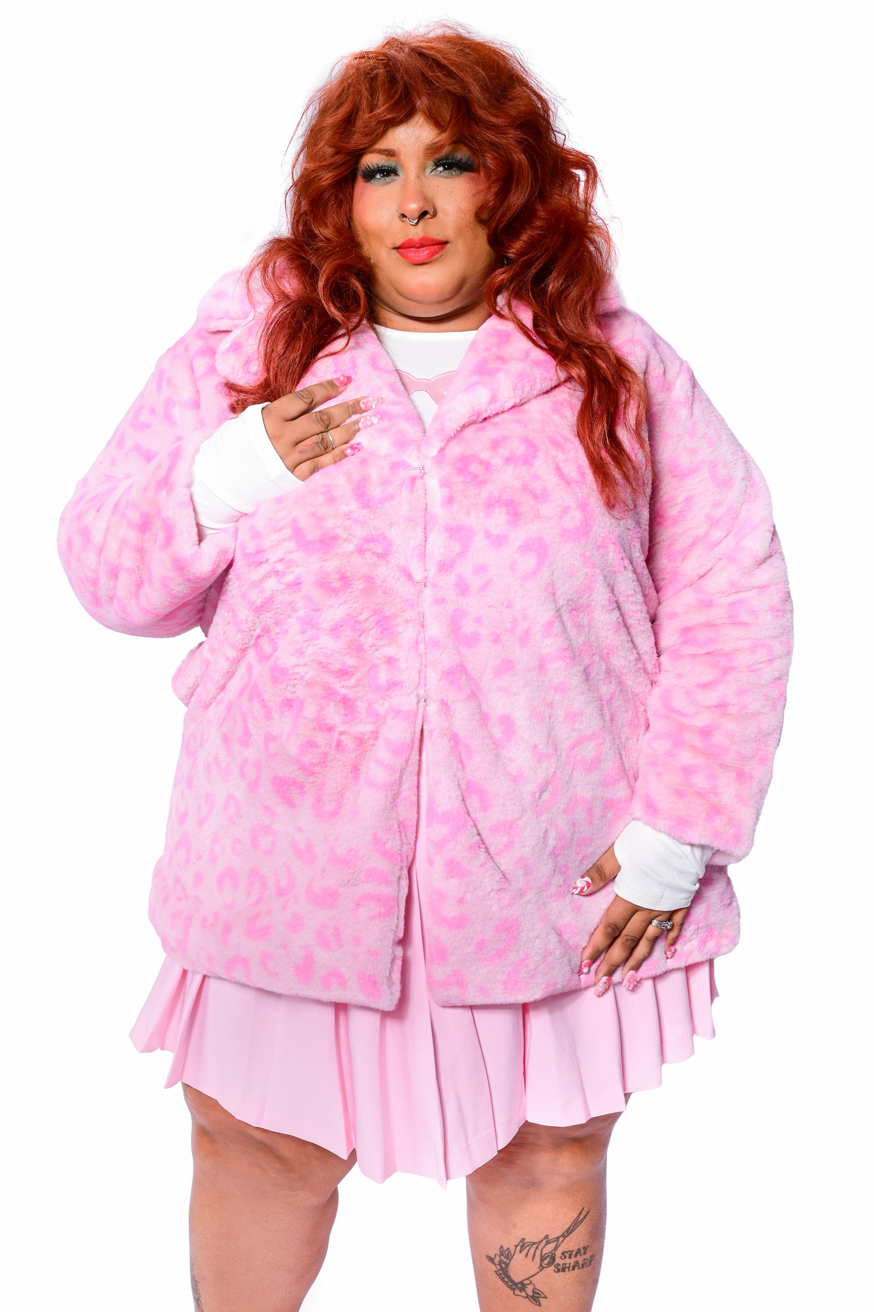 A person wearing a pink leopard print faux fur coat