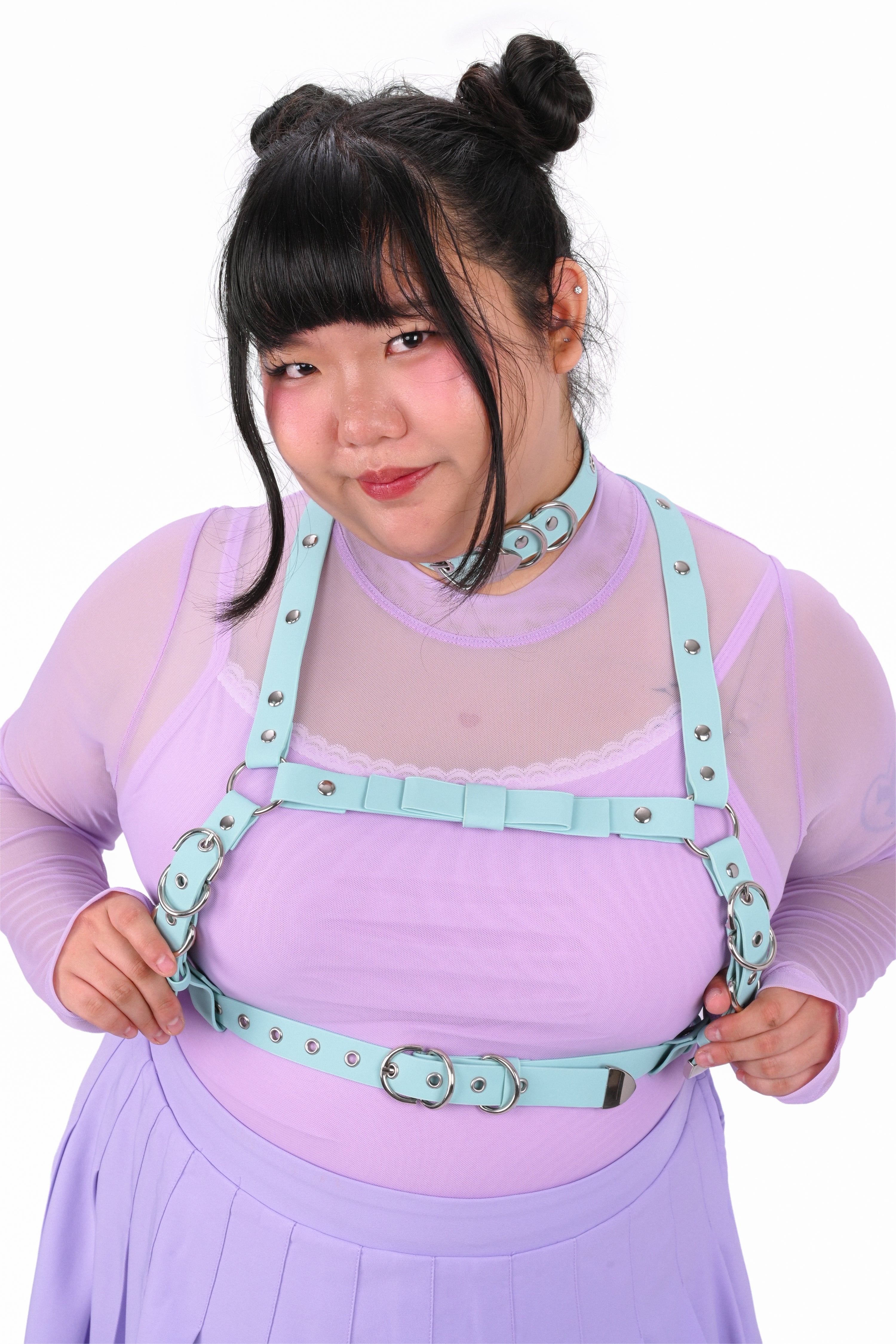 Person wearing a purple outfit with a light blue harness on a white background