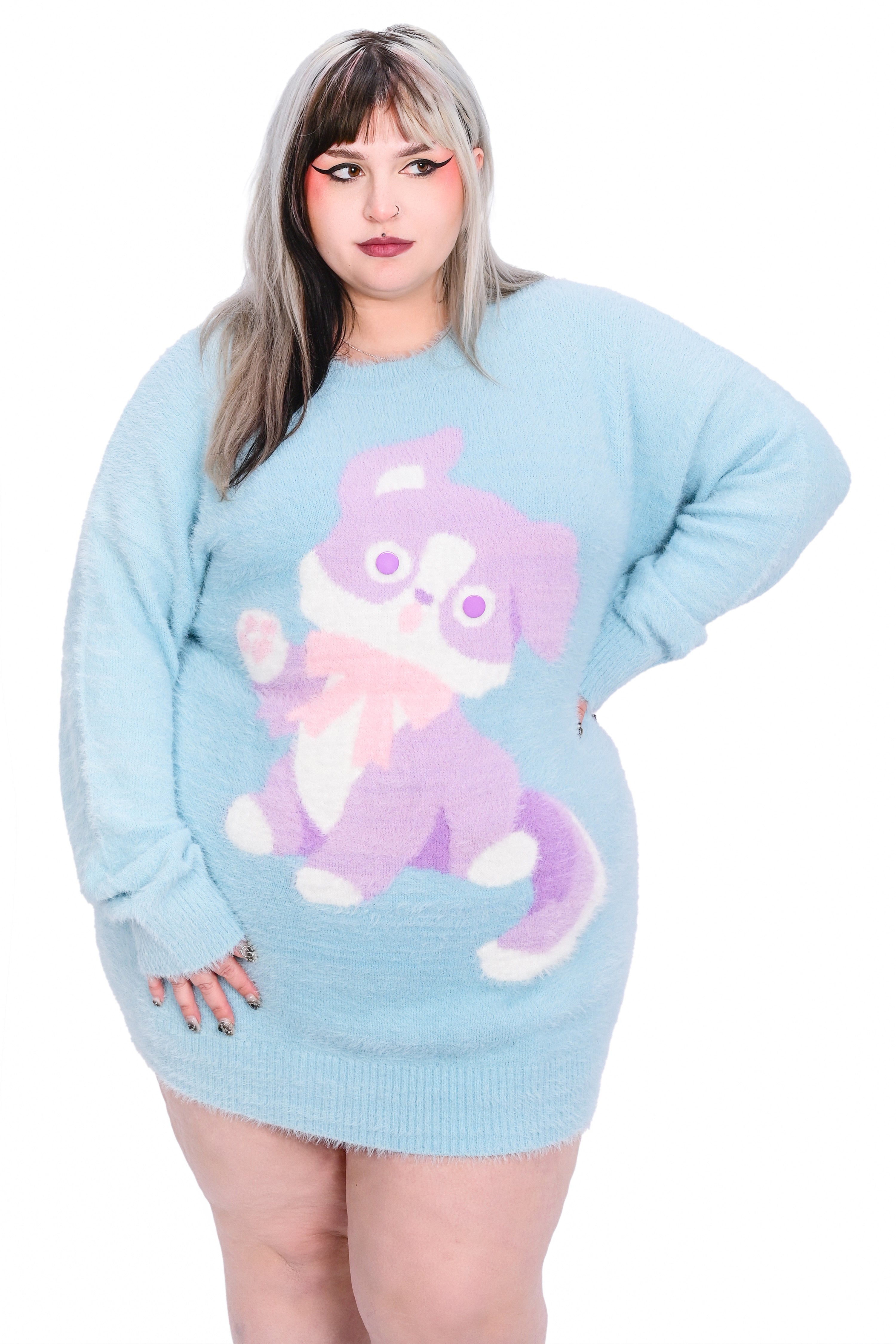 A person wearing a fluffy light blue pullover with a knit puppy design.