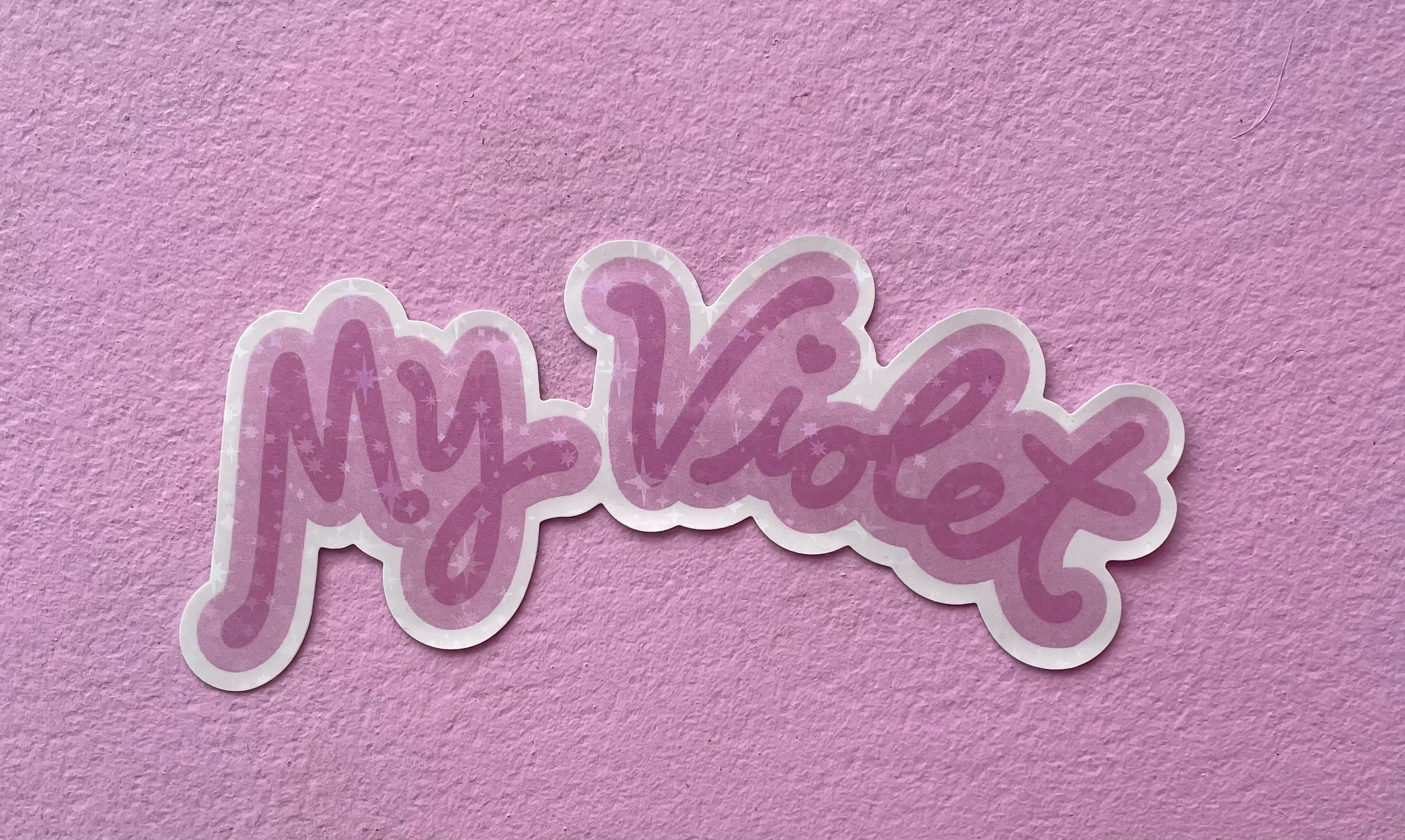 A pink glittery sticker with the text 'My Violet' on a pink background.