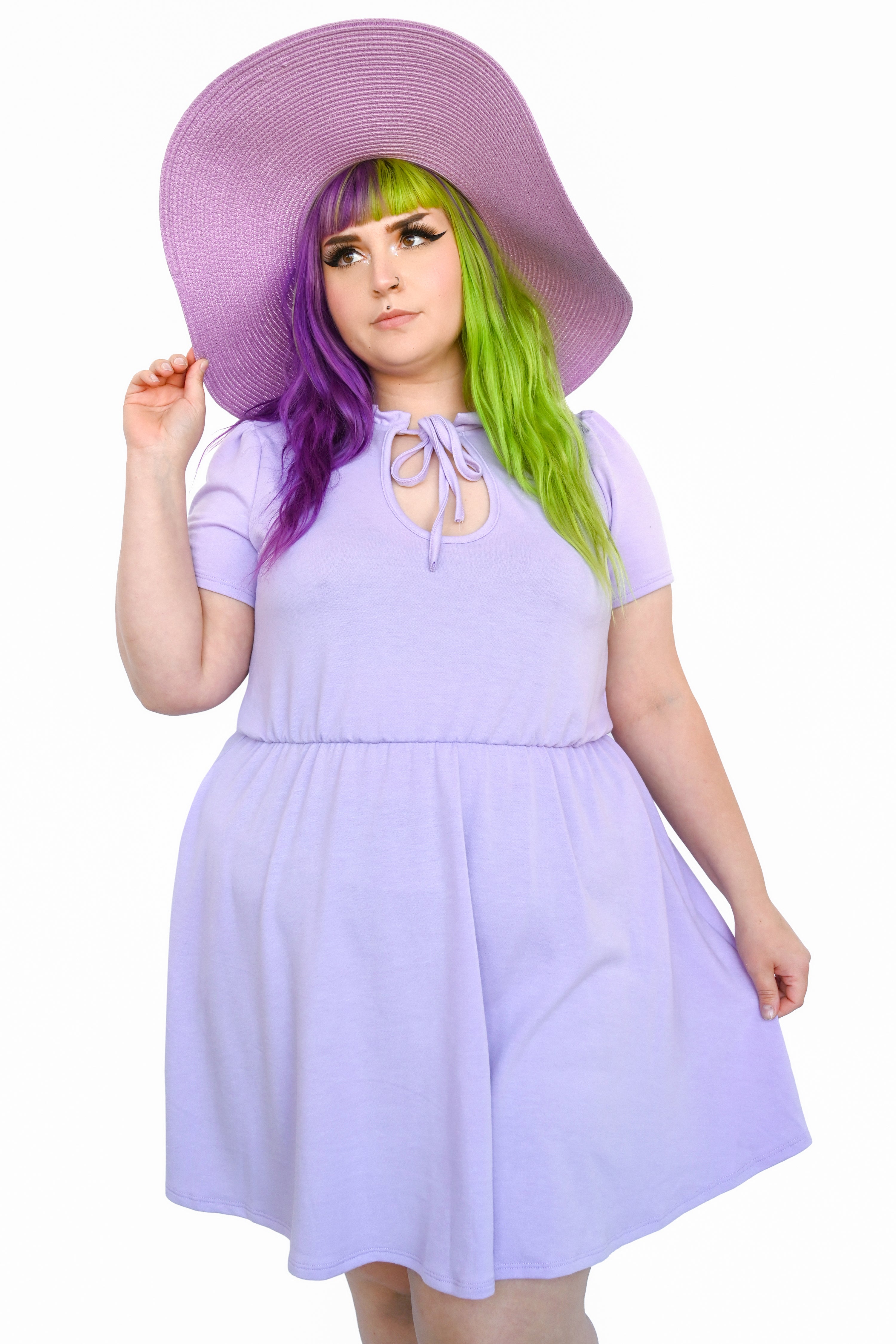 A person wearing a lavender dress with a key hole cutout at the neckline