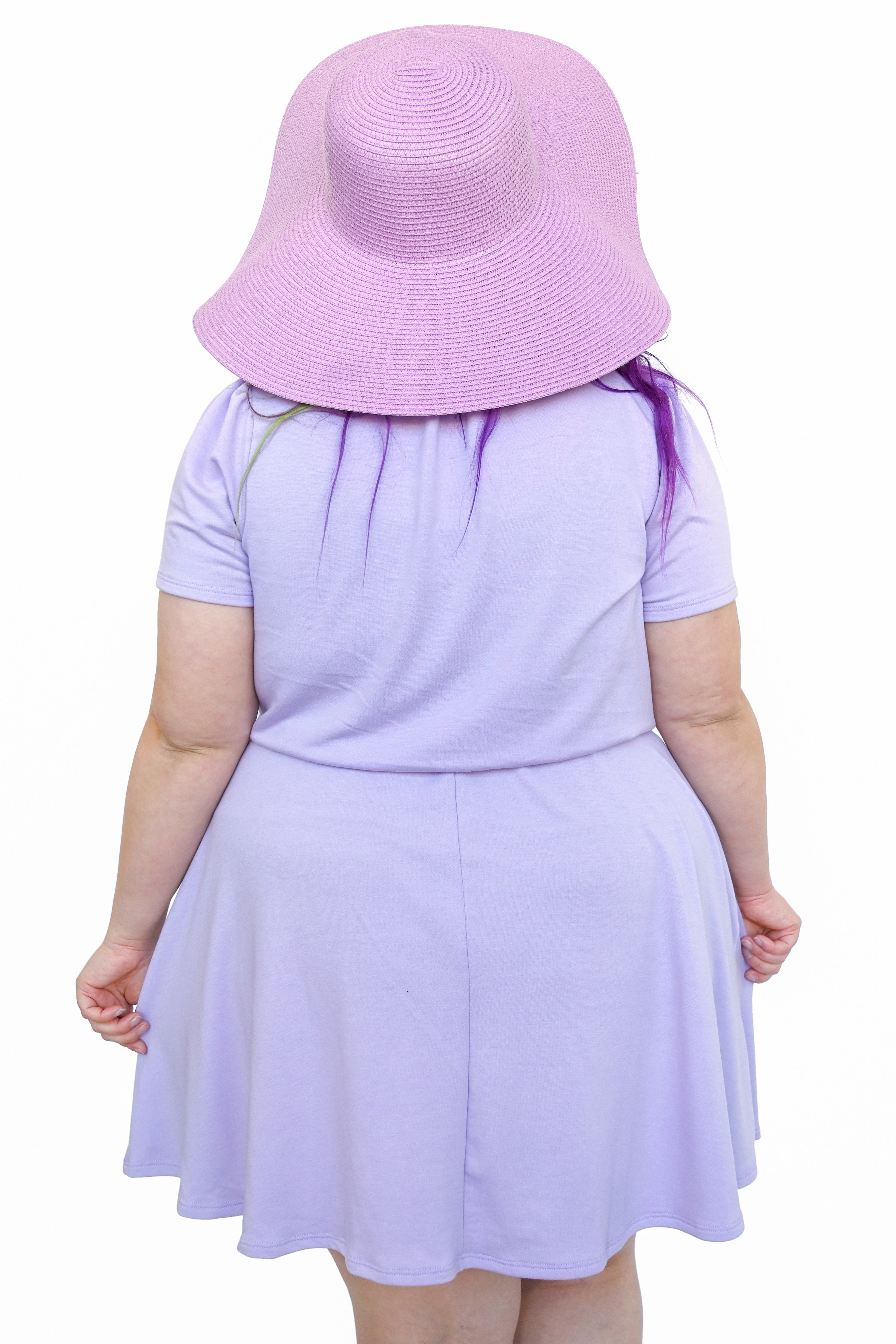 A person wearing a lavender dress with a key hole cutout at the neckline