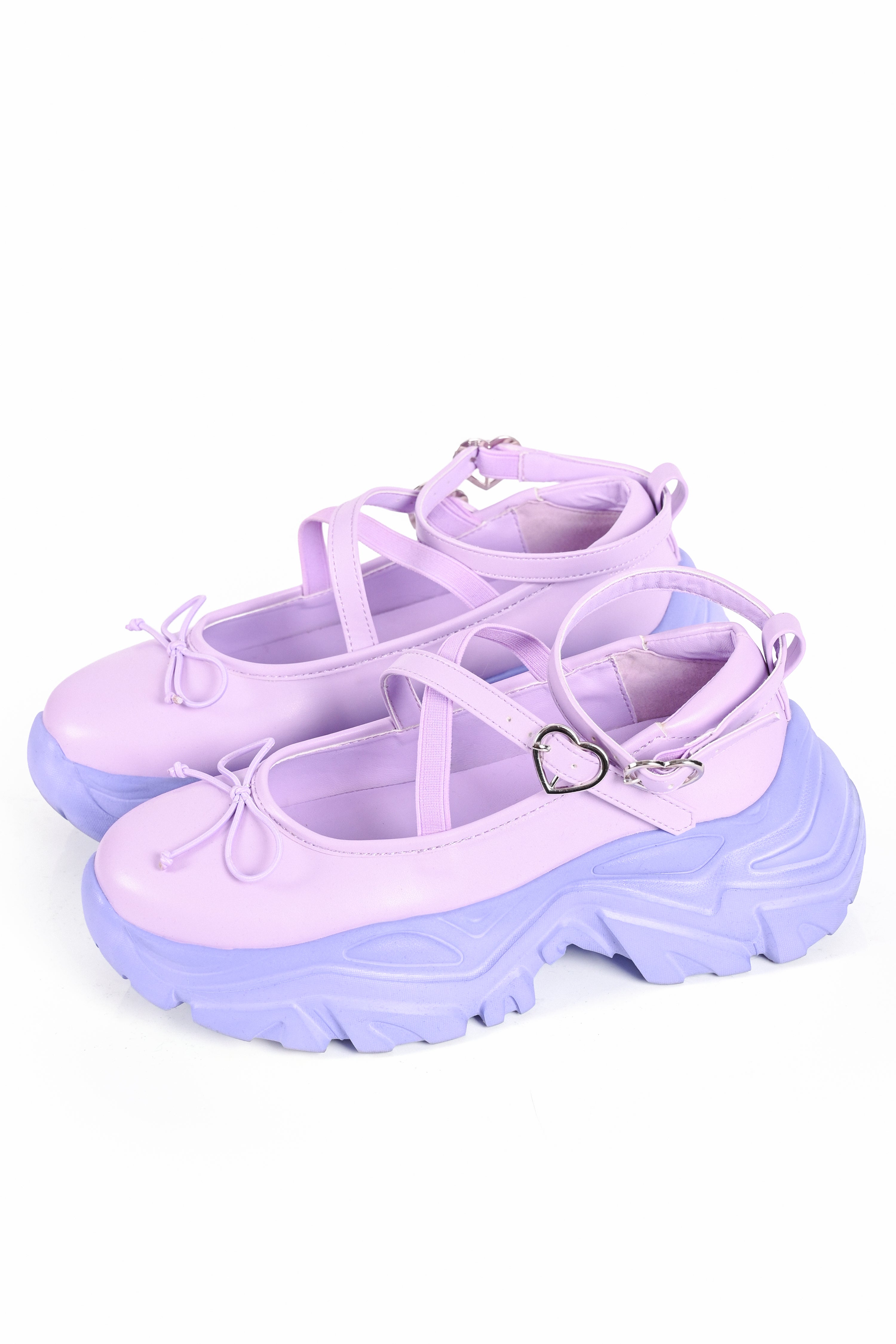 Pair of purple platform shoes with heart detail on a white background