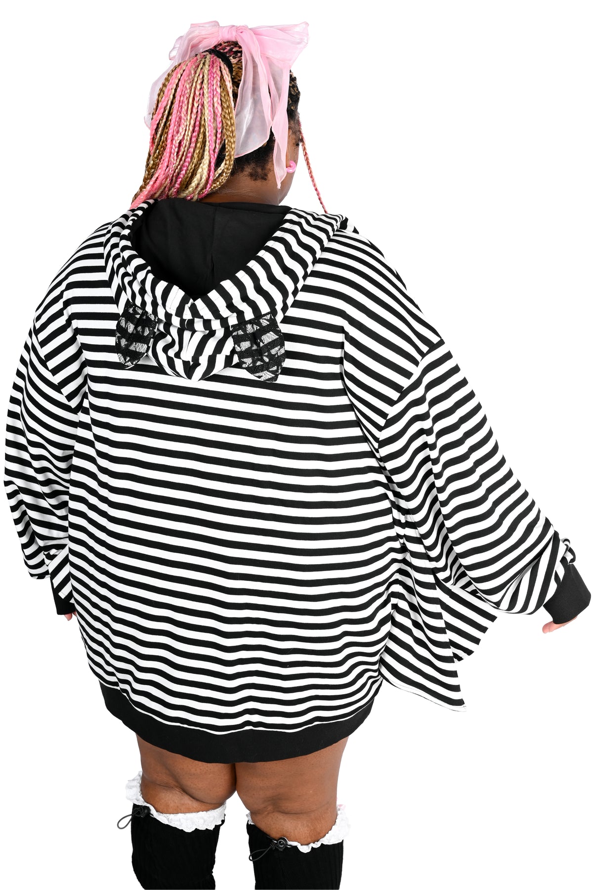 A plus size model shown from the back wearing an oversized black-and-white horizontally striped hoodie with a black hood with lace bat ears on top, paired with black leg warmers and knee-high socks. The background is solid white.