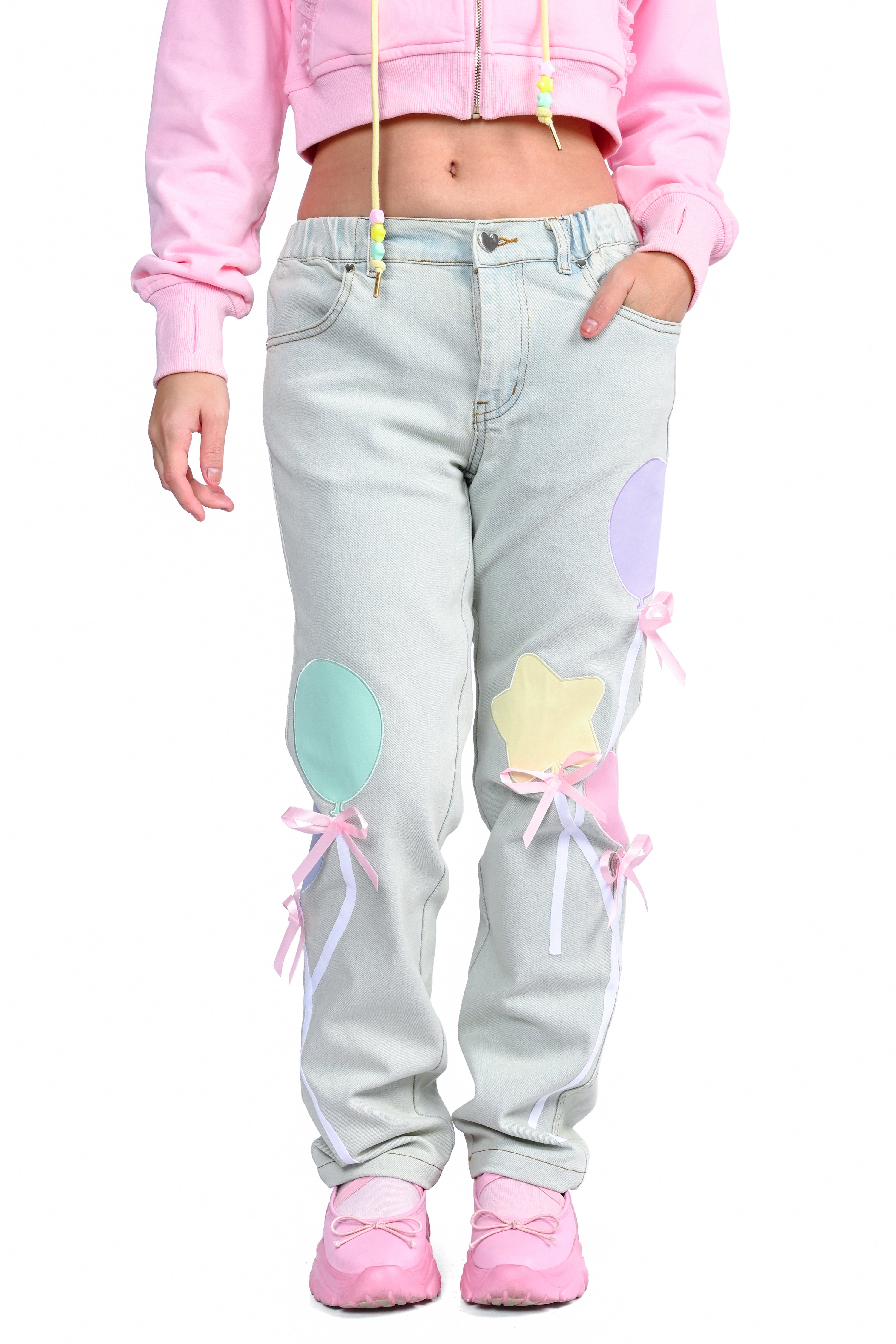 minty light was cotton jeans with colorful balloon patches worn by a woman on a white background
