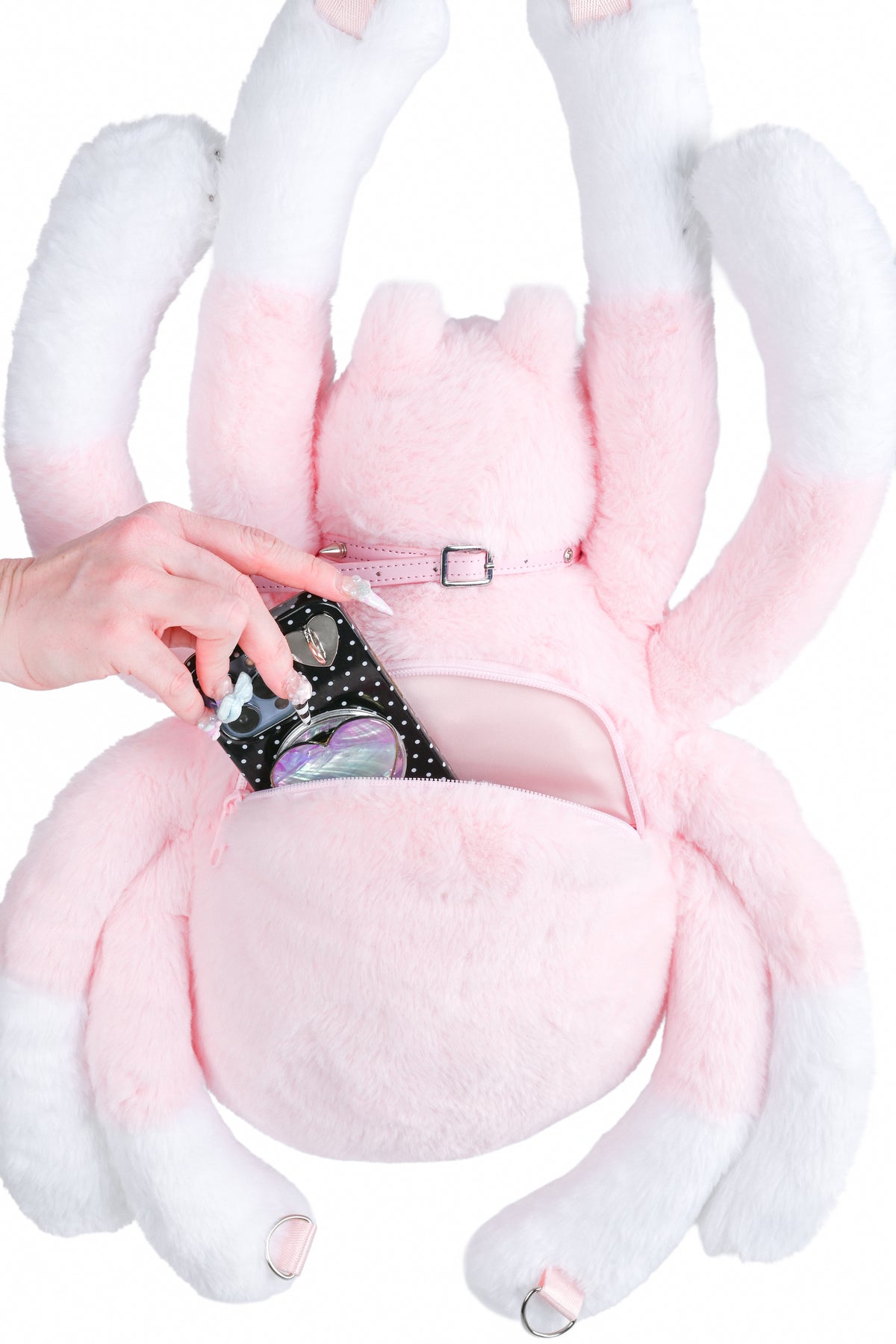 Close up of spider bag with a hand placing a phone it the pocket.