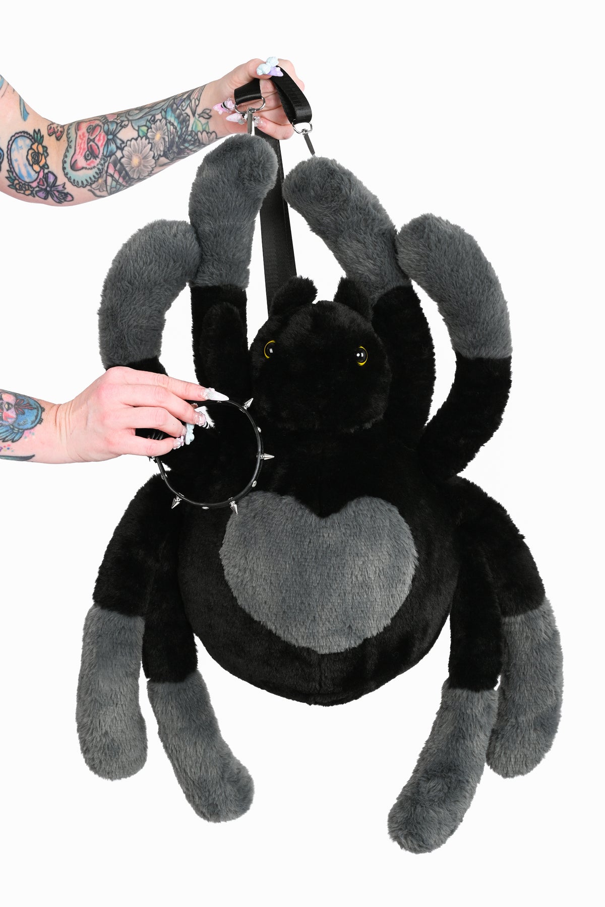 Hand holding black spider bag with matching choker, highlighting that the choker is removable.