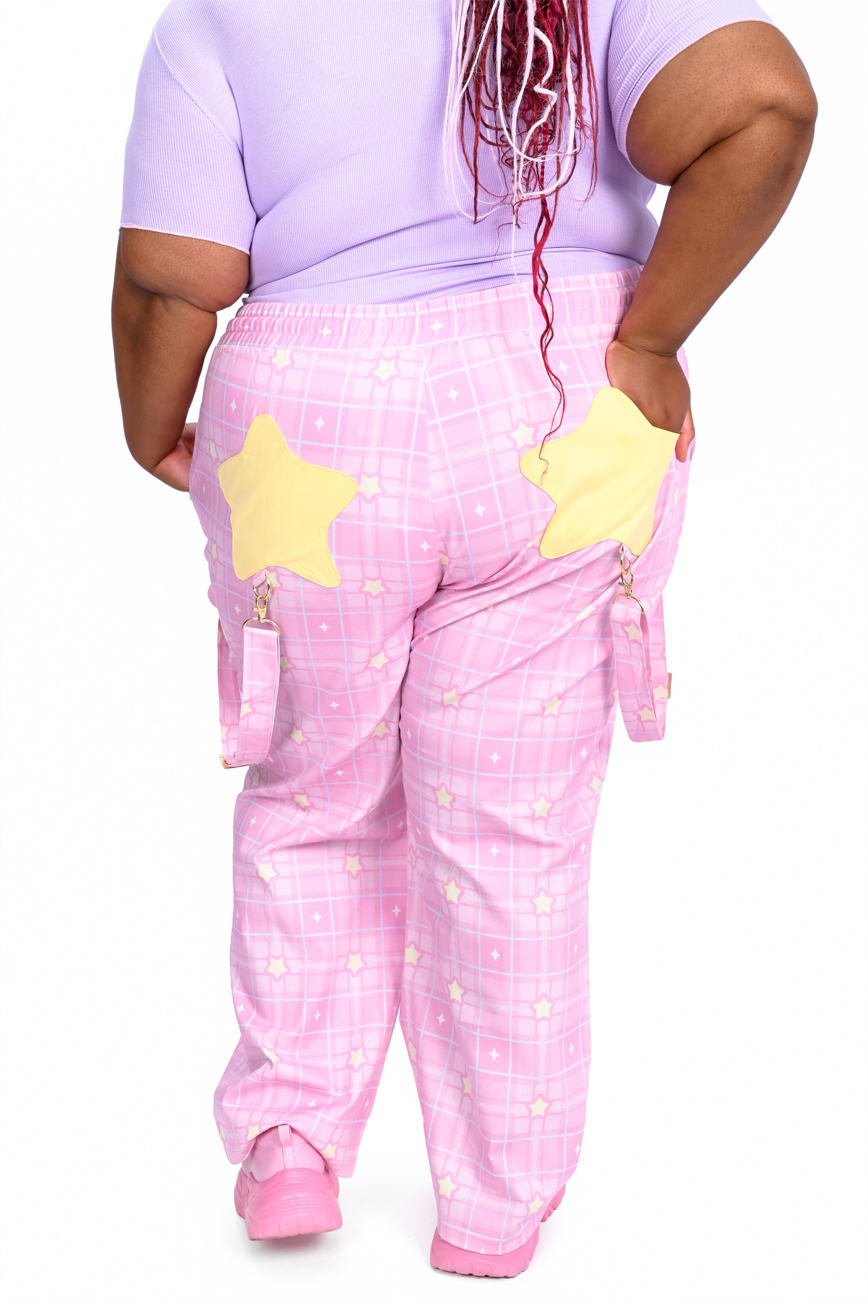 Person wearing a pink outfit with yellow star designs on a white background