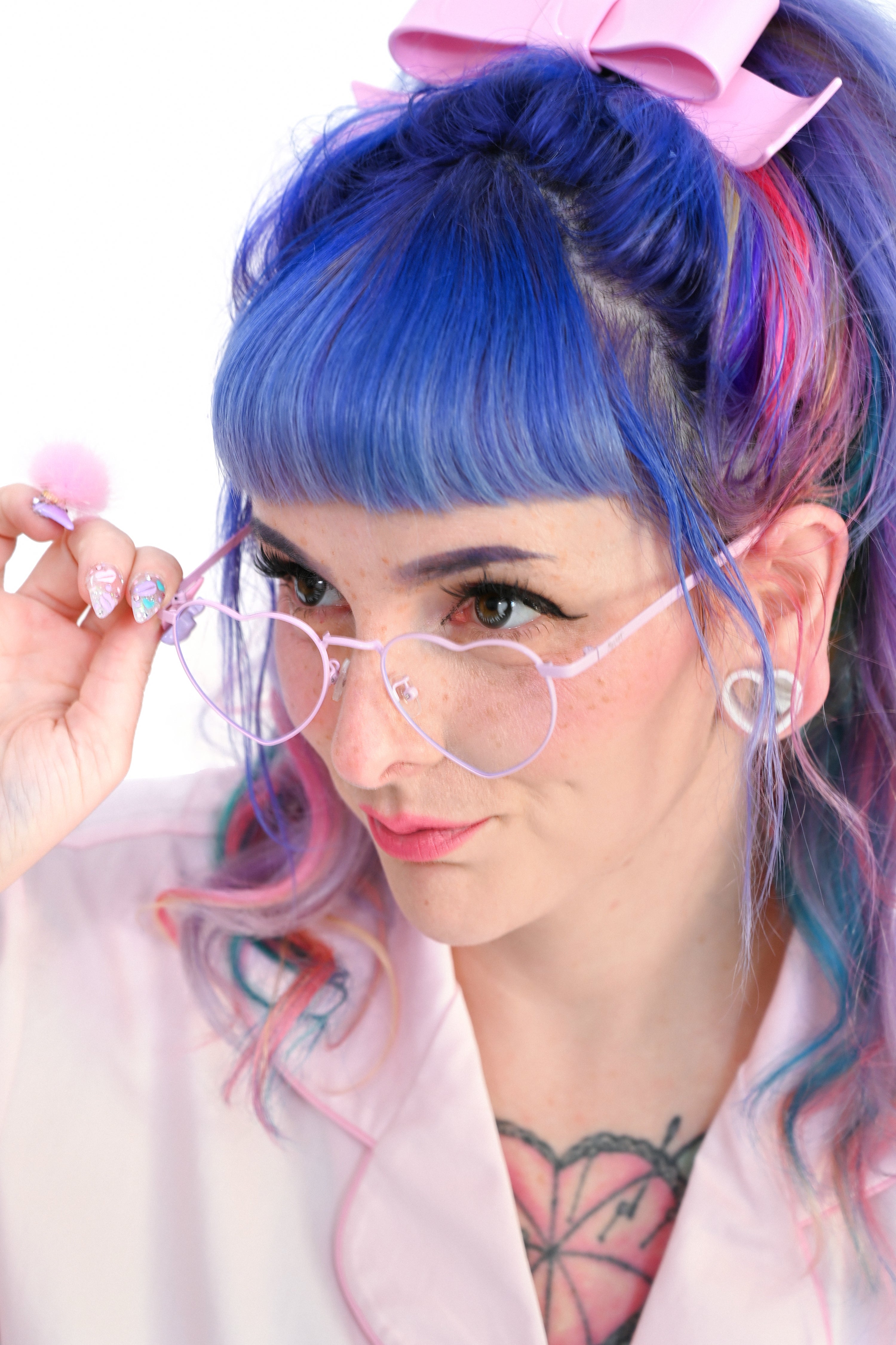 A person wearing pink heart-shaped glasses on a white background
