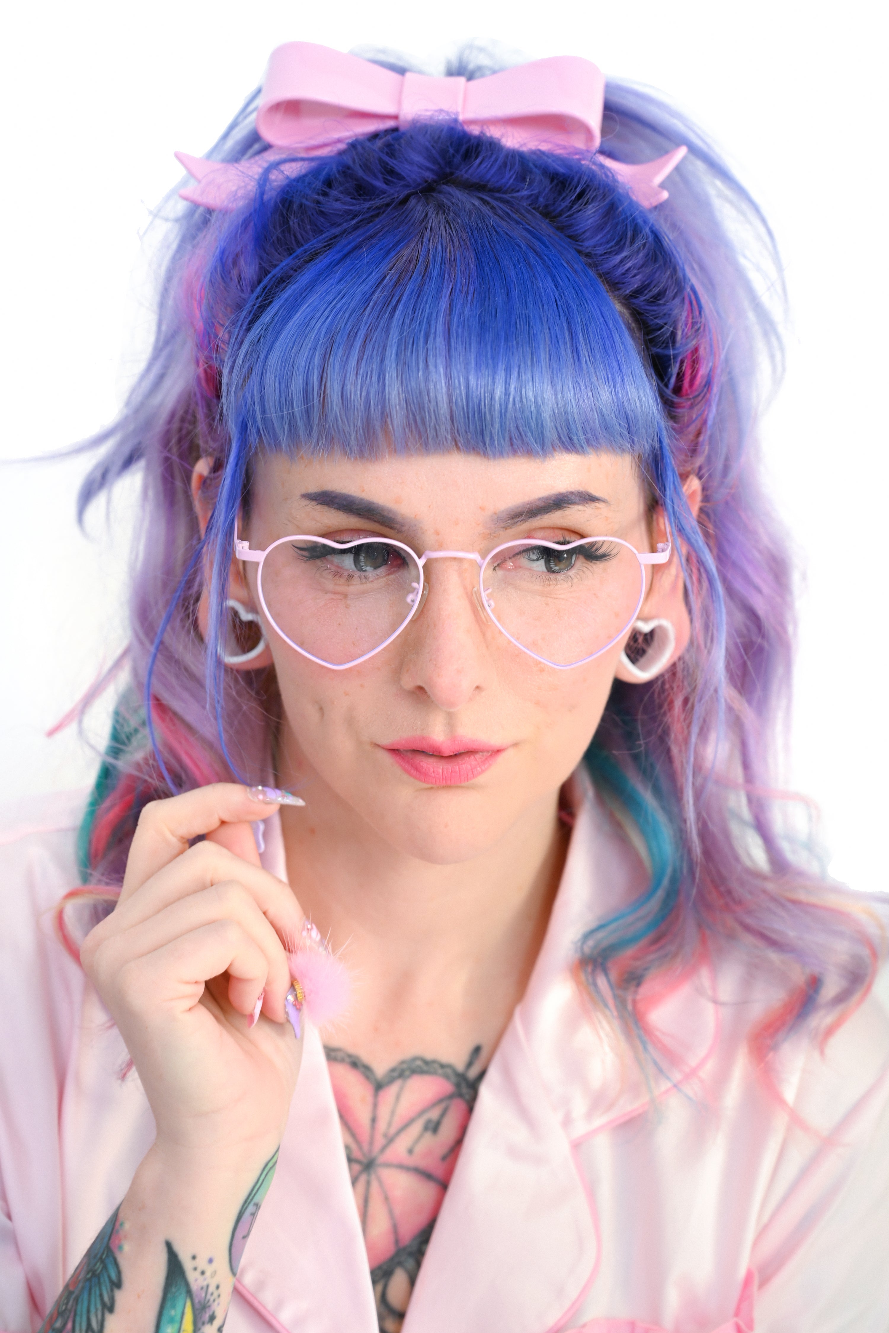 A person wearing pink heart-shaped glasses on a white background