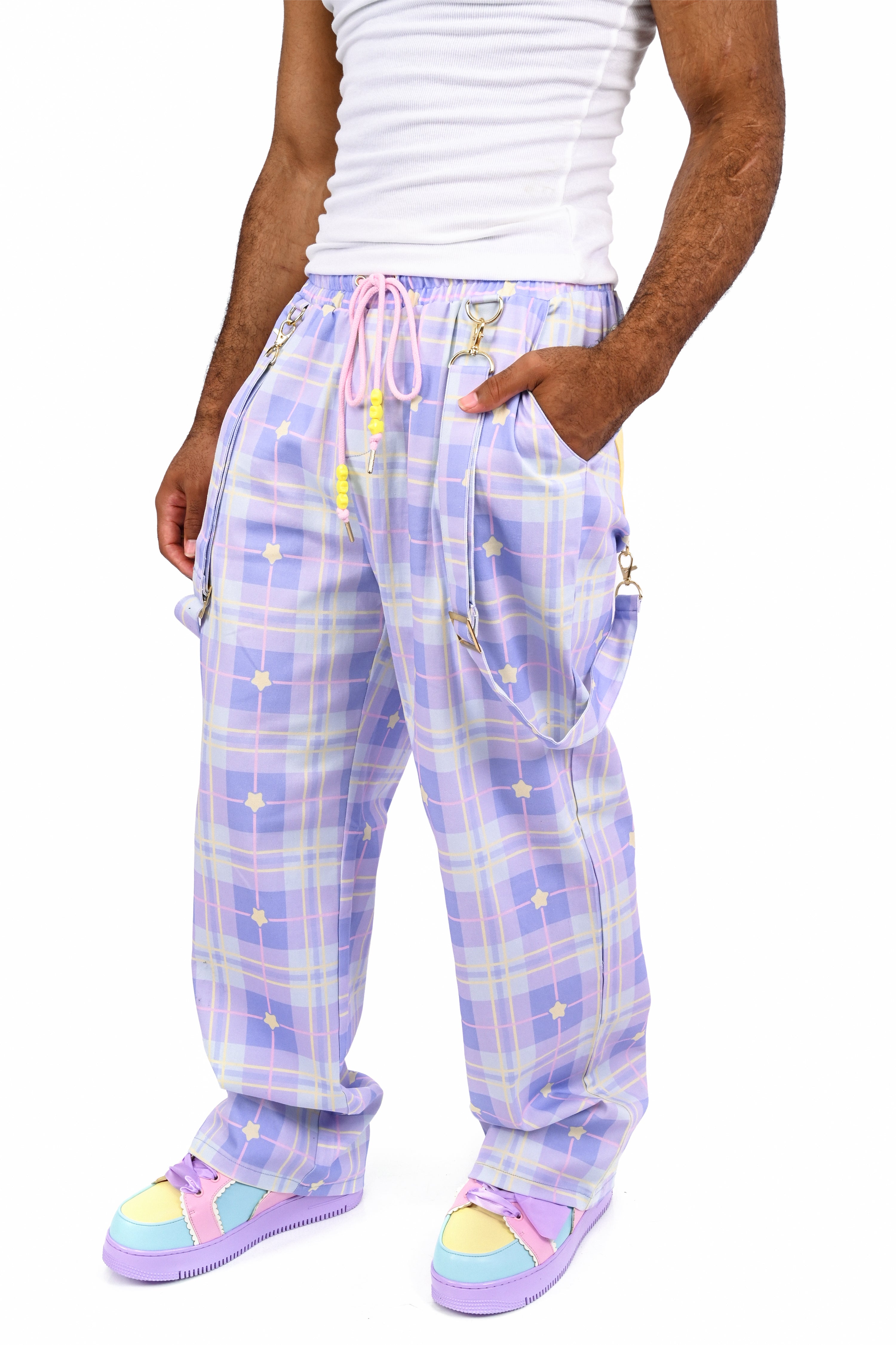 Person wearing purple plaid pajama pants with star patterns on a white background