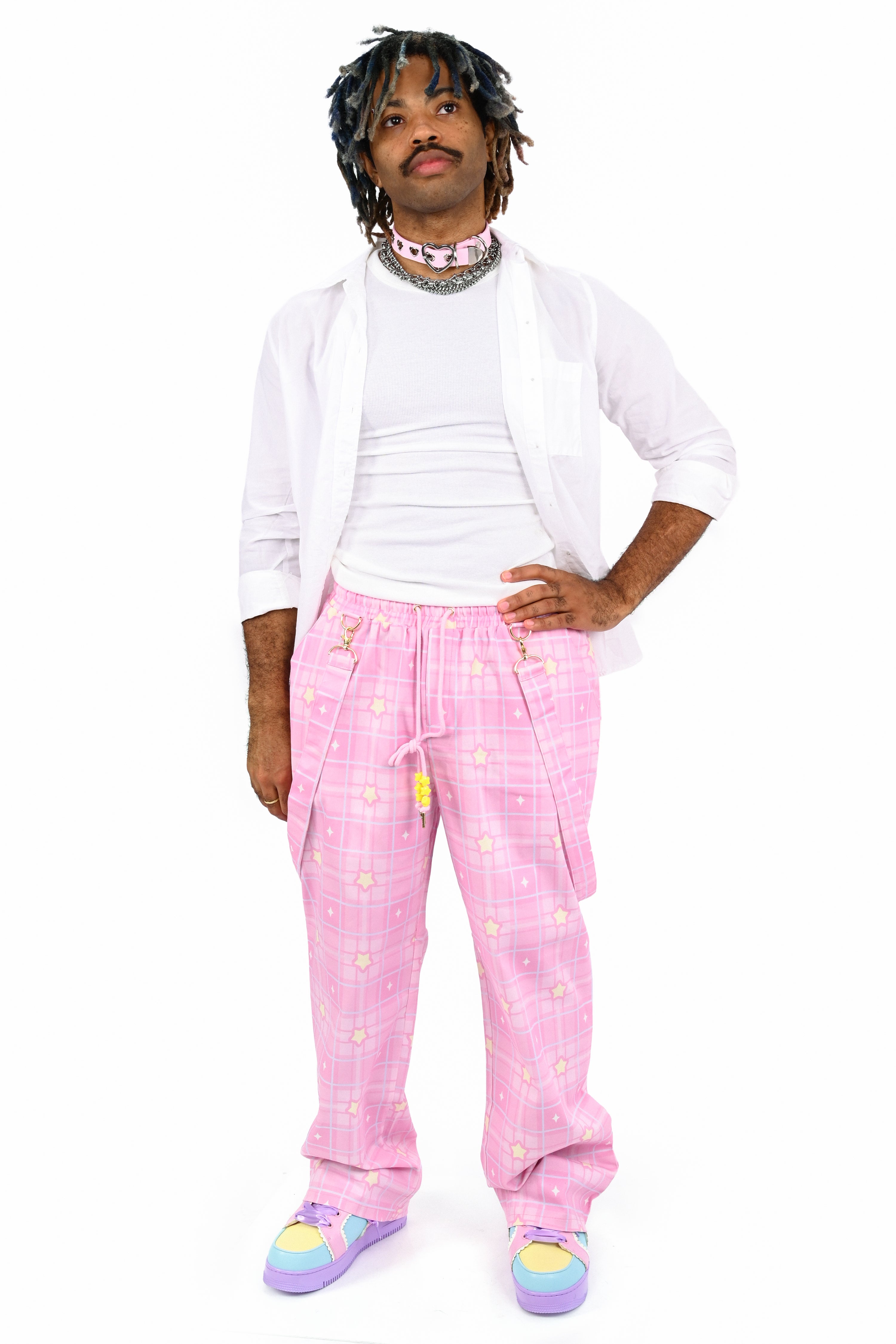 Person wearing a white sweatshirt and pink checkered pants on a white background