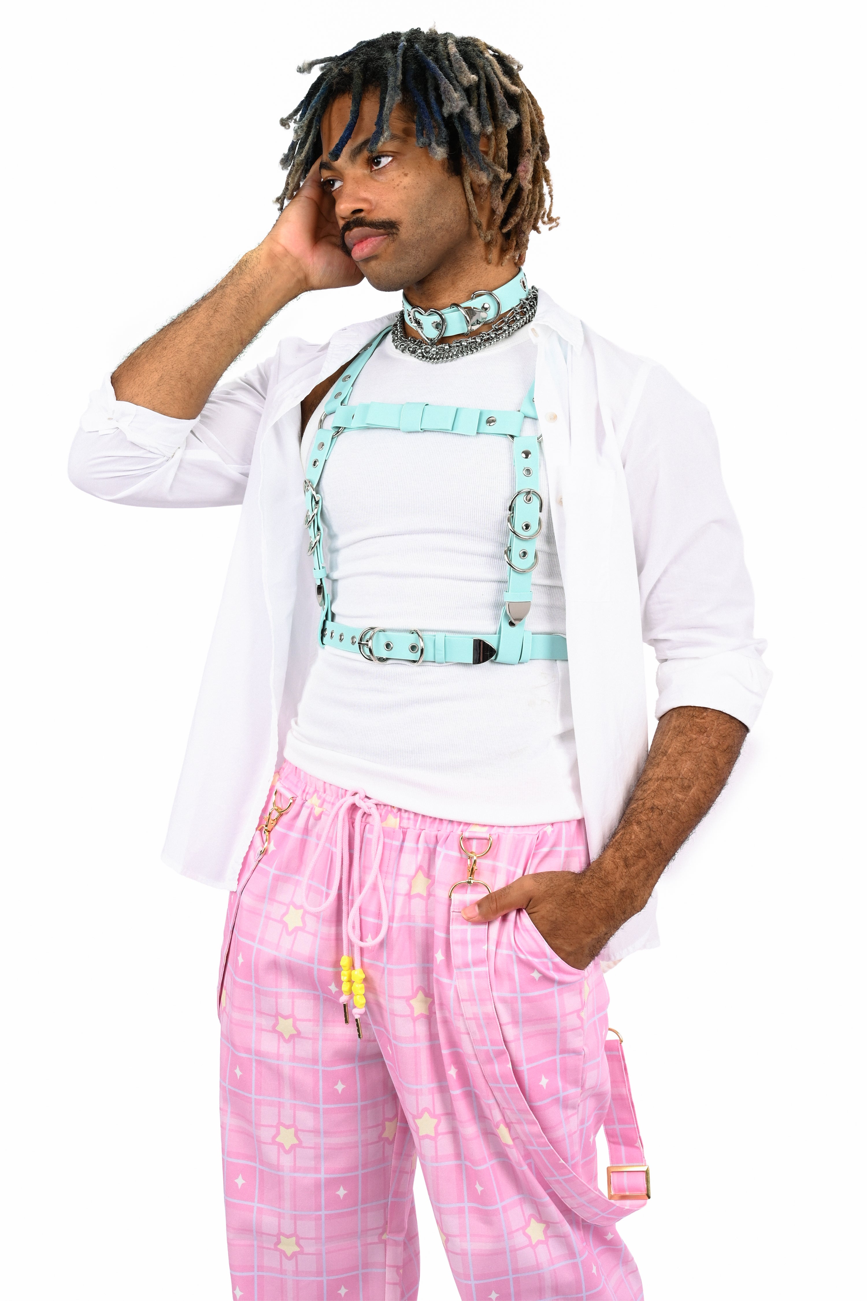 Person wearing a white shirt, pink pants, and a light blue harness on a white background