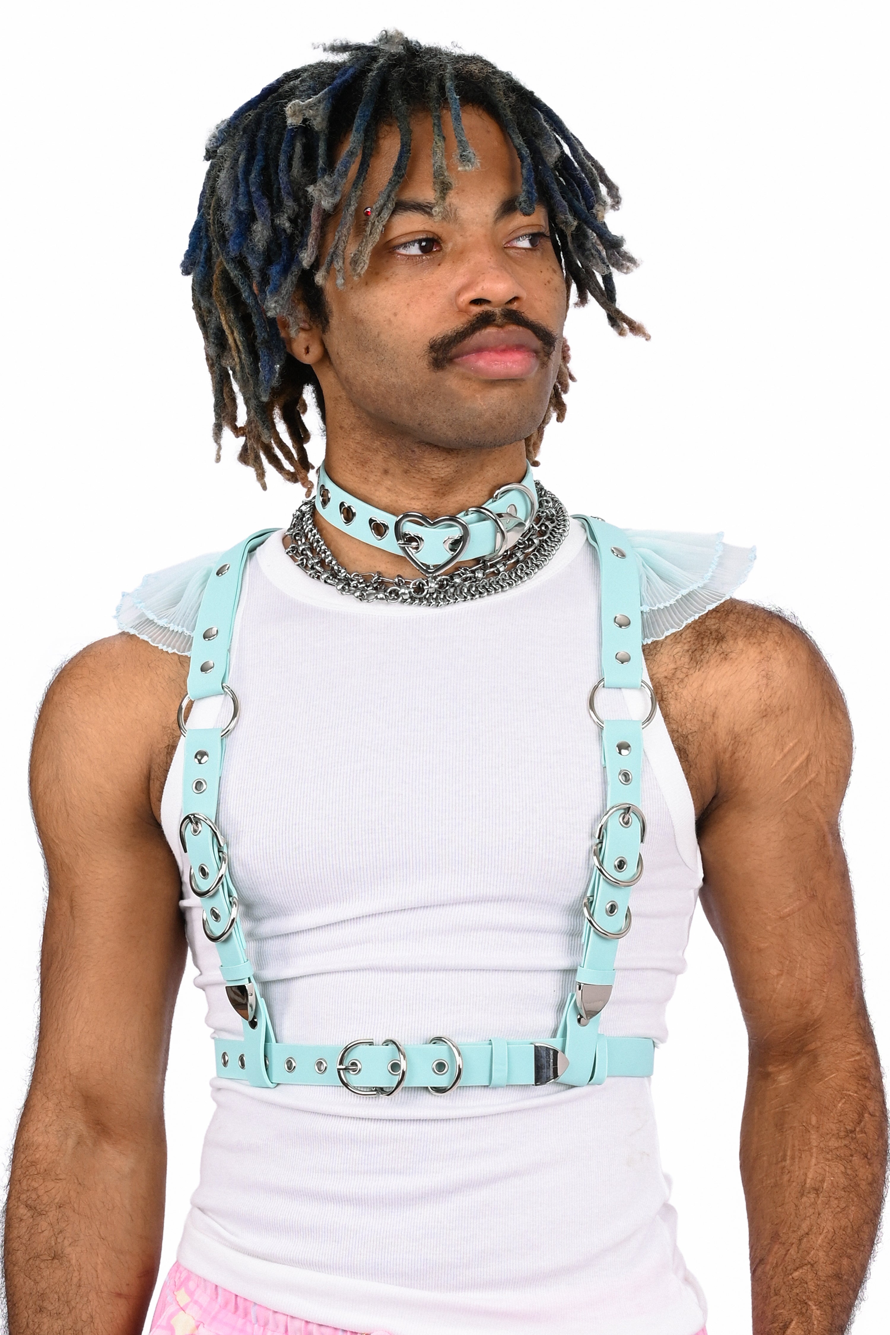 Person wearing a white tank top with light blue suspenders on a white background