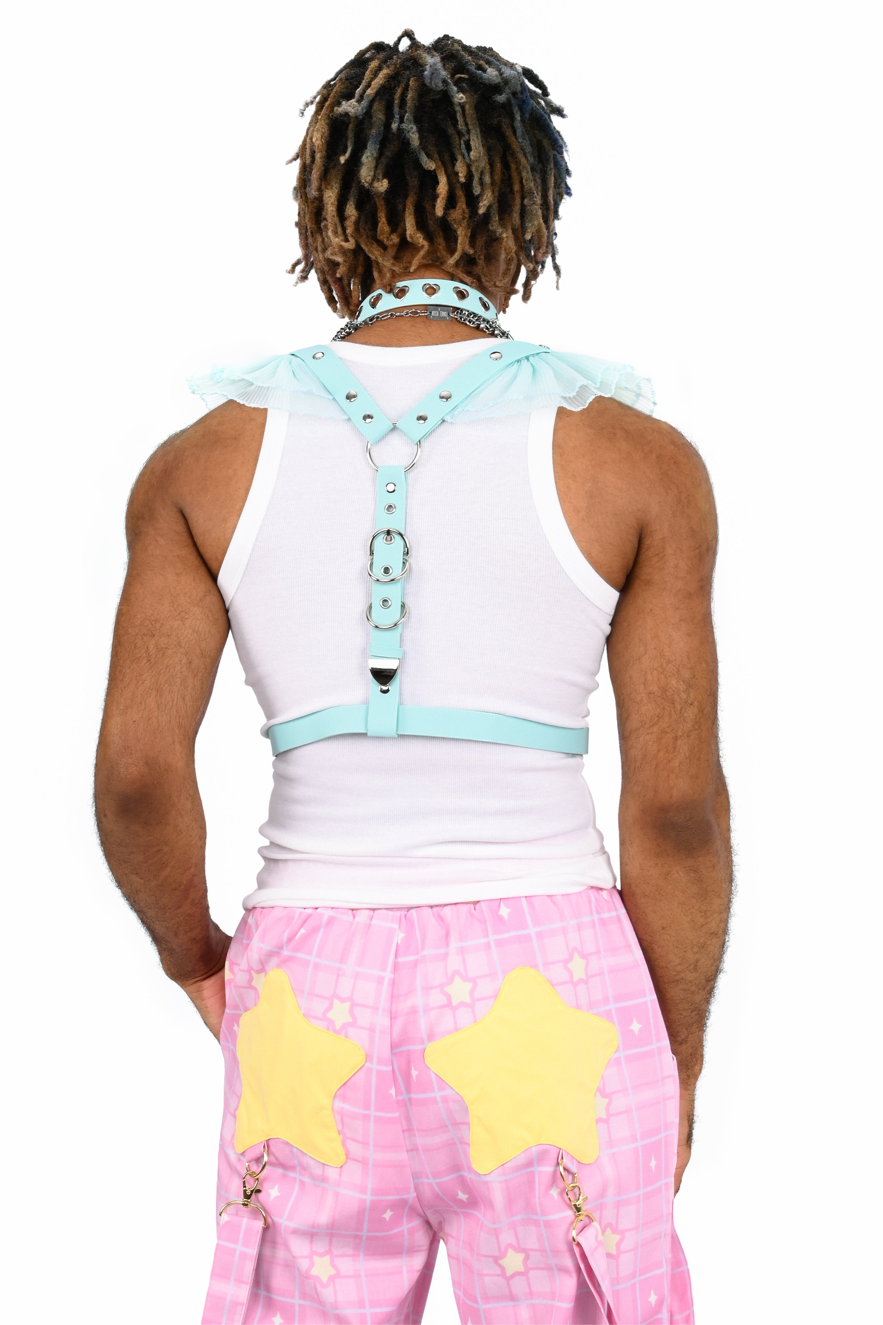 Person wearing a white tank top with light blue straps and pink pants with yellow stars on a white background
