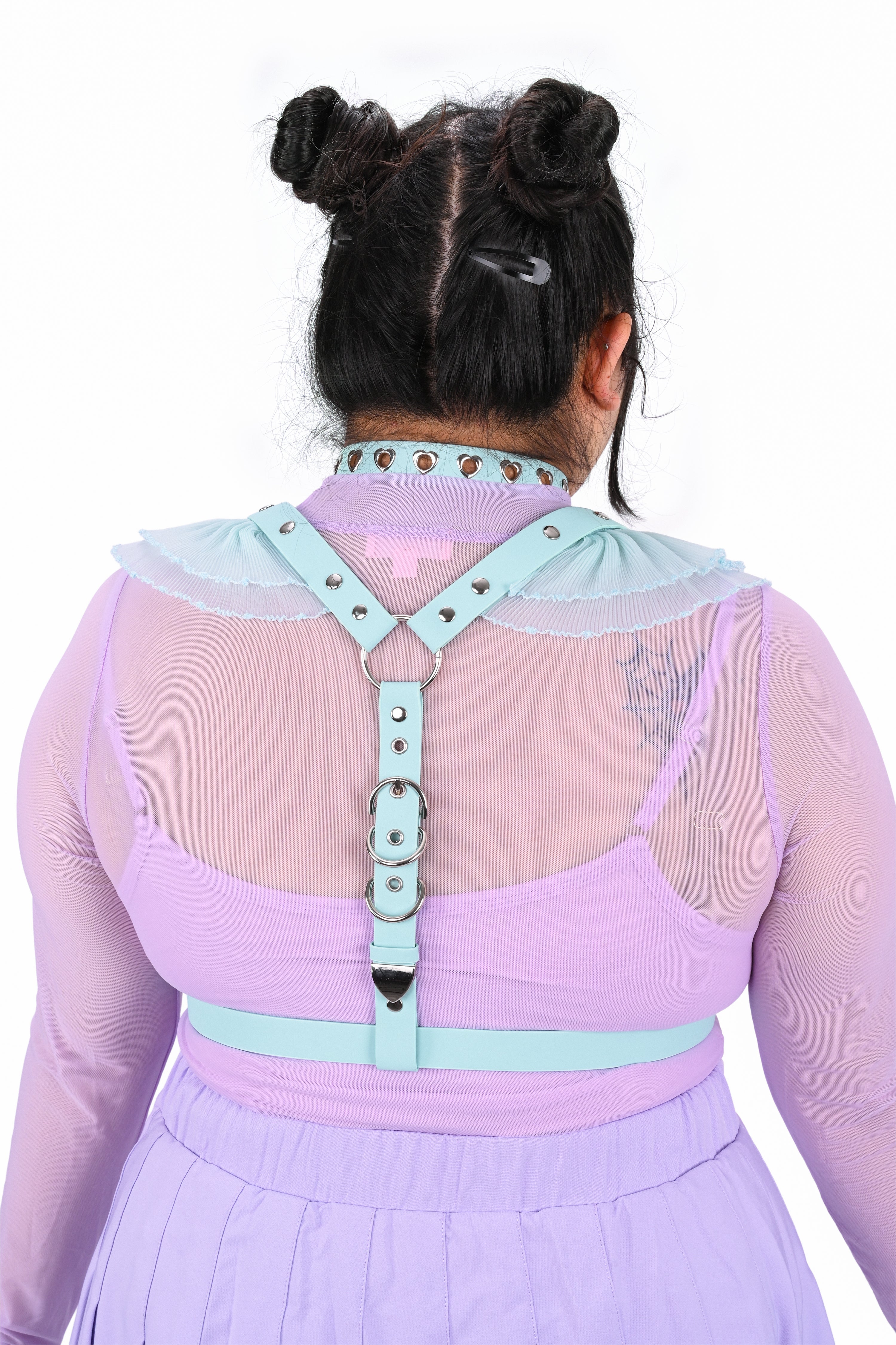 Person wearing a pastel-colored outfit with a unique back design on a white background