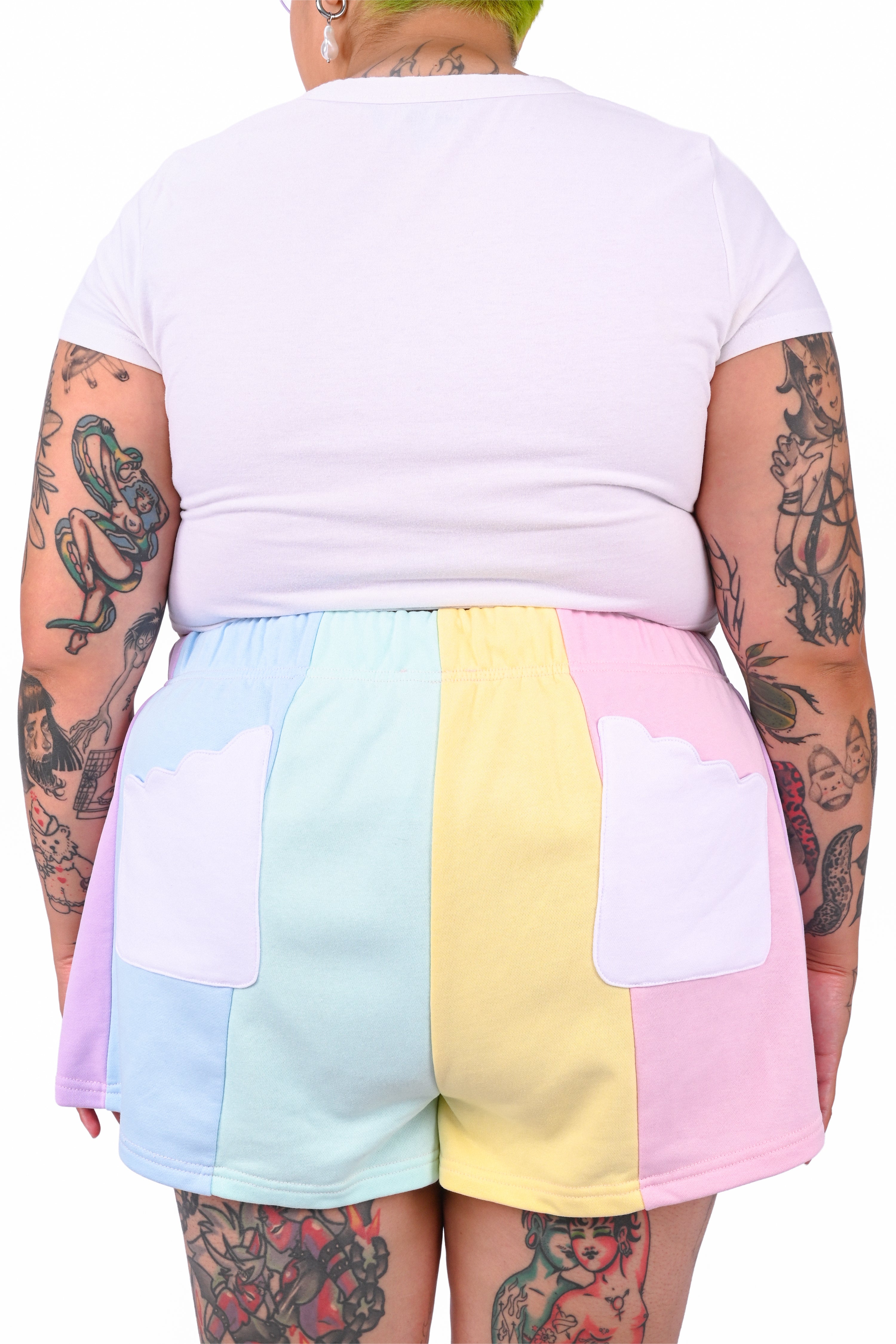Person wearing a white t-shirt and colorful color blocked shorts