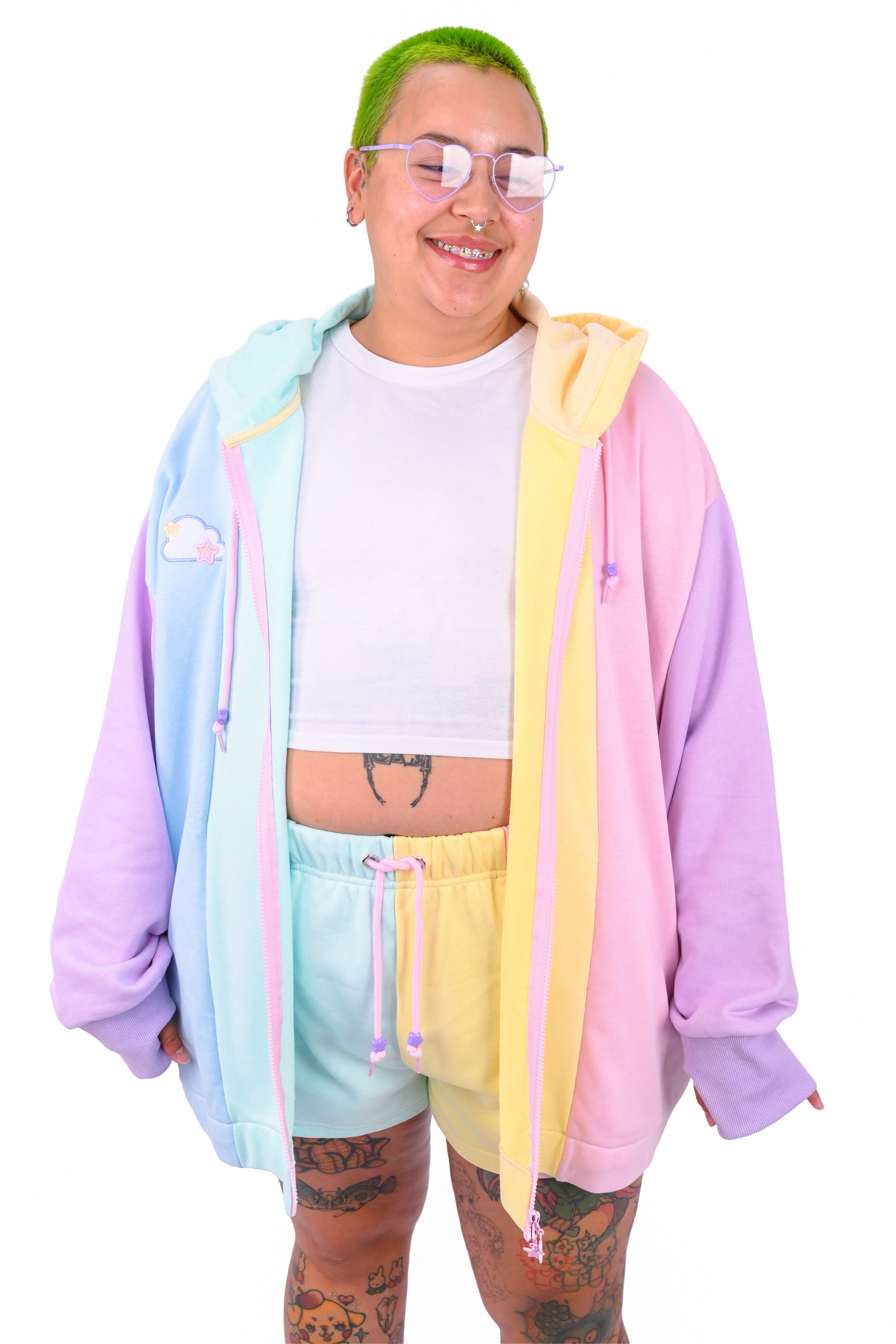 Person wearing a white t-shirt and colorful color blocked shorts, with a matching rainbow hoodie