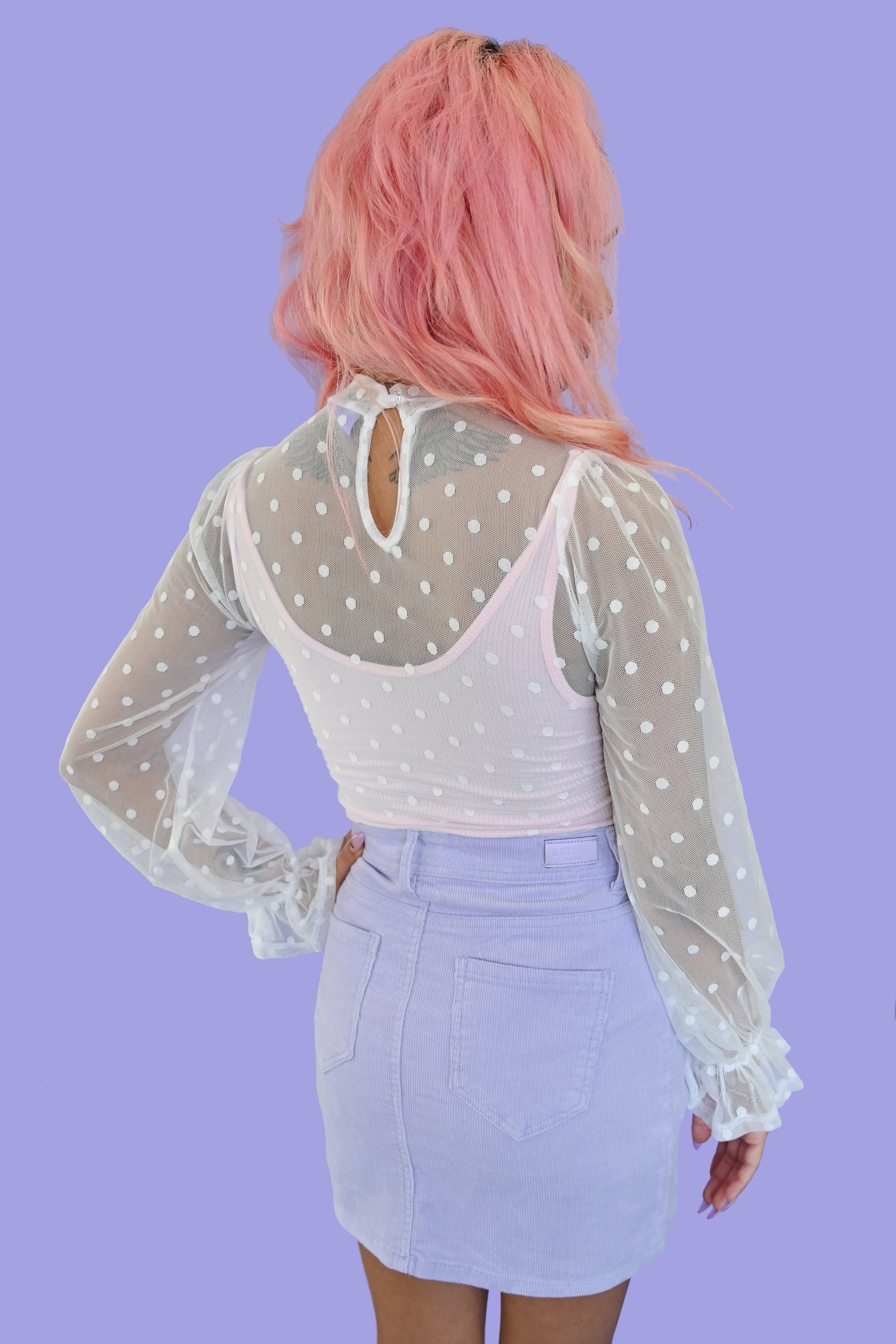 sheer white polka dot blouse with ruffled sleeves and a peephole button closure on the back