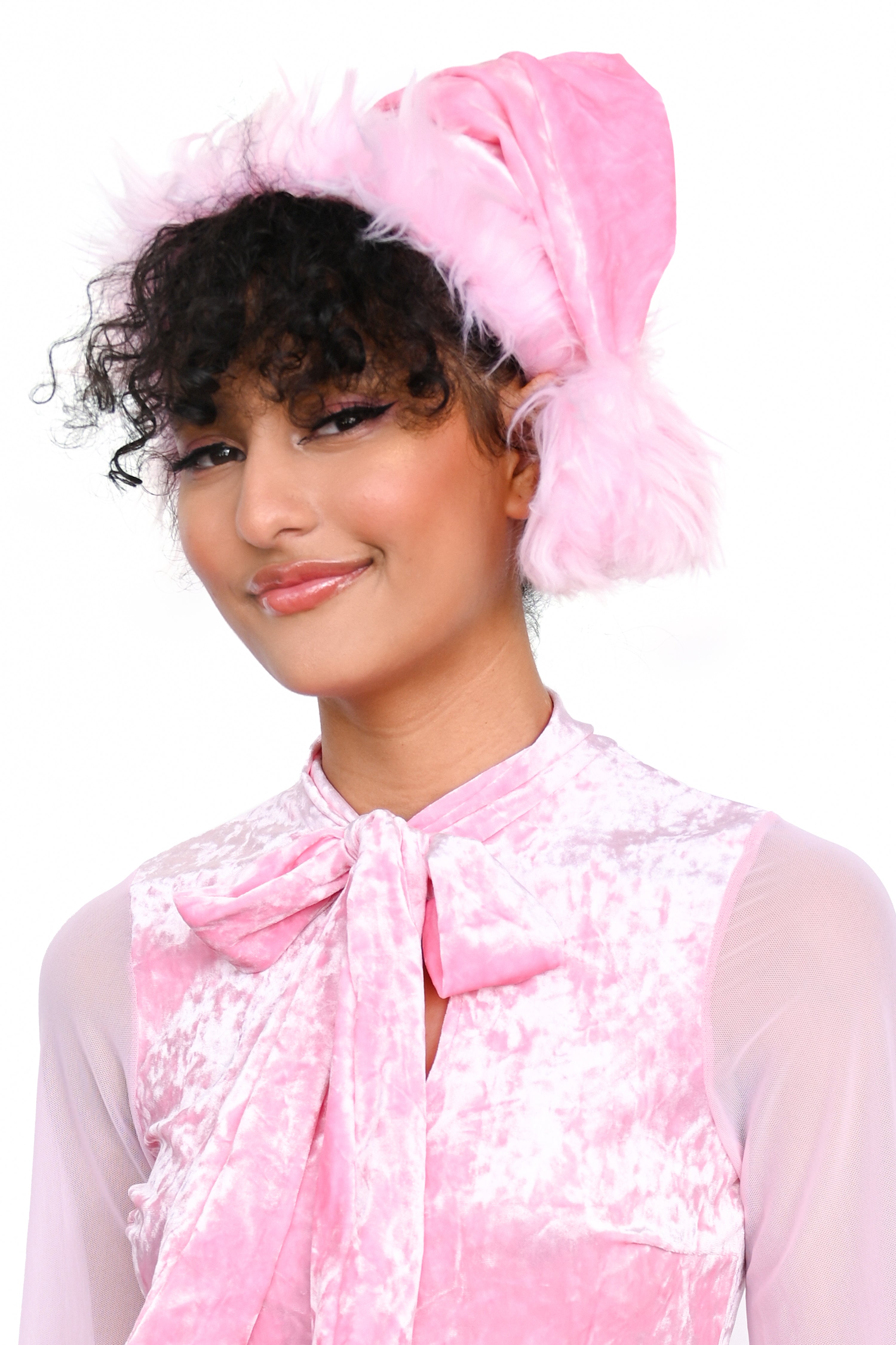 A Santa hat with pink crushed velvet body and pink faux fur trim and pom pom