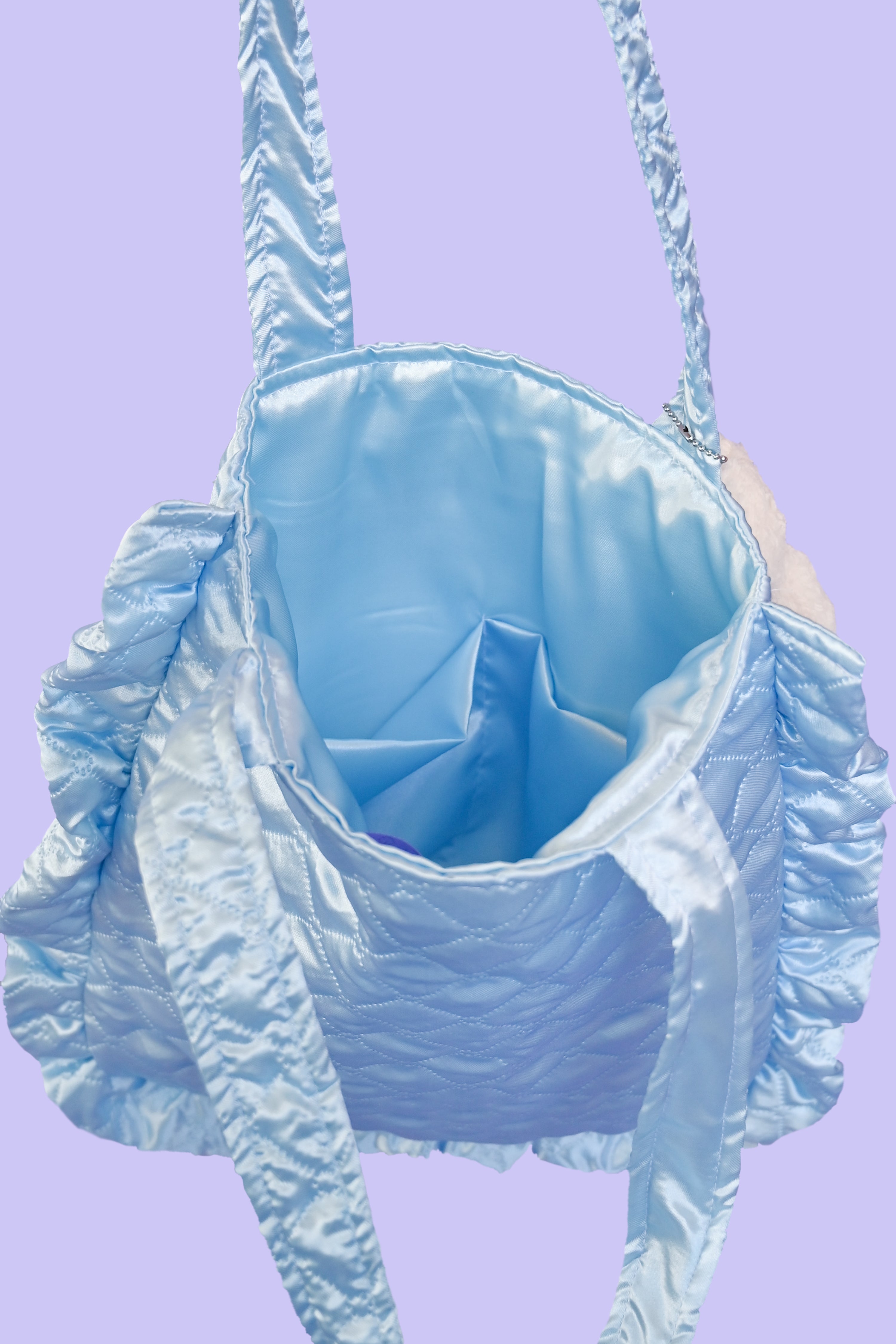 soft quilted blue satin tote bag with a chunky ruffled edge and extra inside pockets 