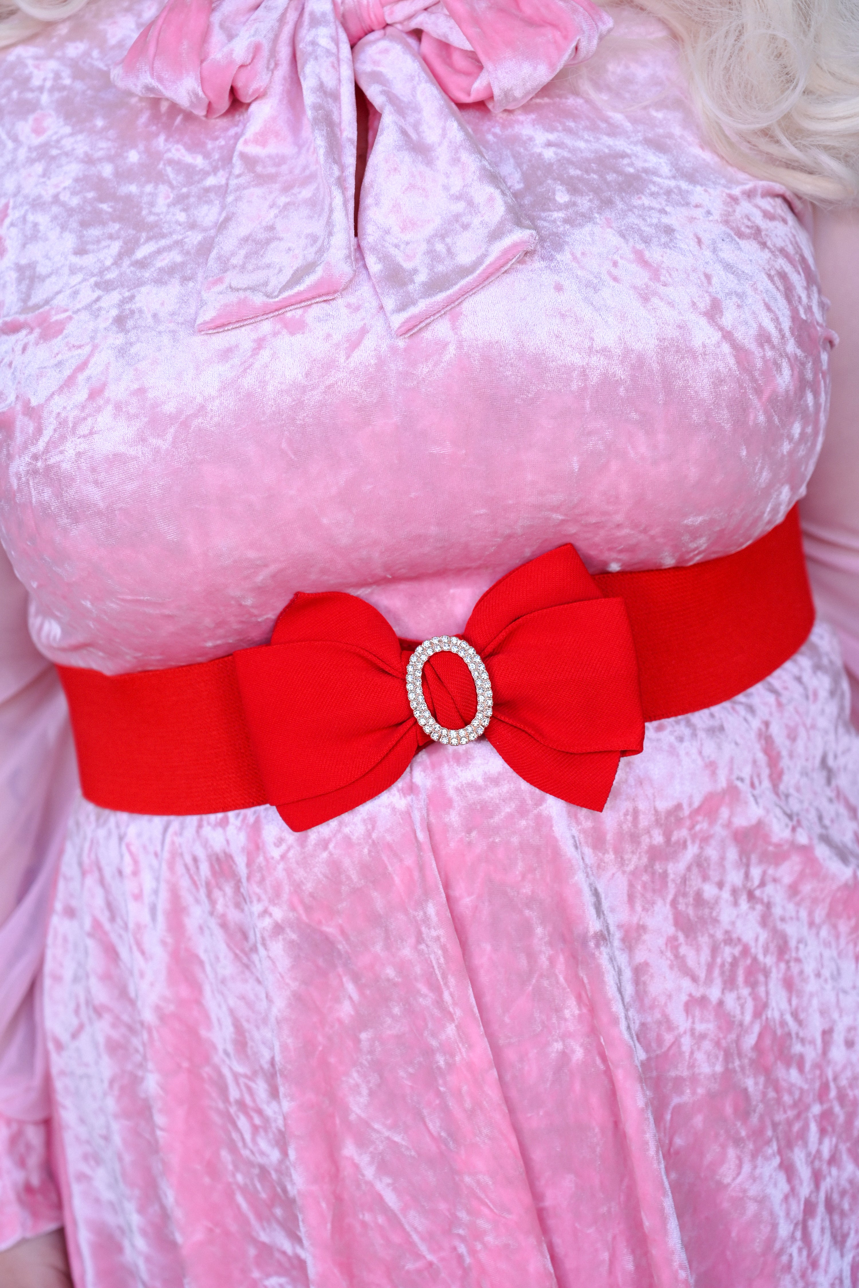 A red belt with a big rhinestone bow and elastic waist