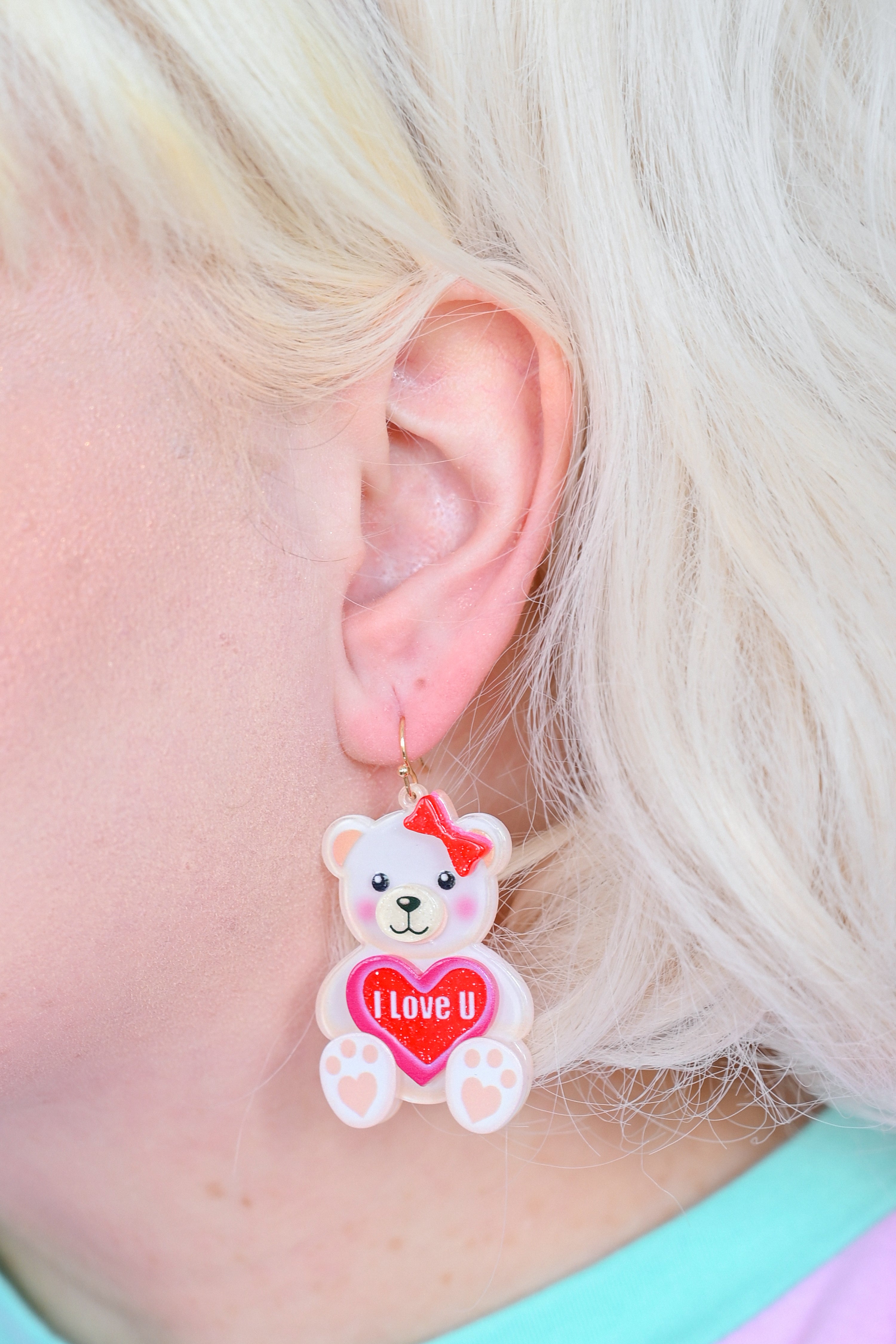 White teddy bear earrings with a red bow holding a heart that says "I love U"