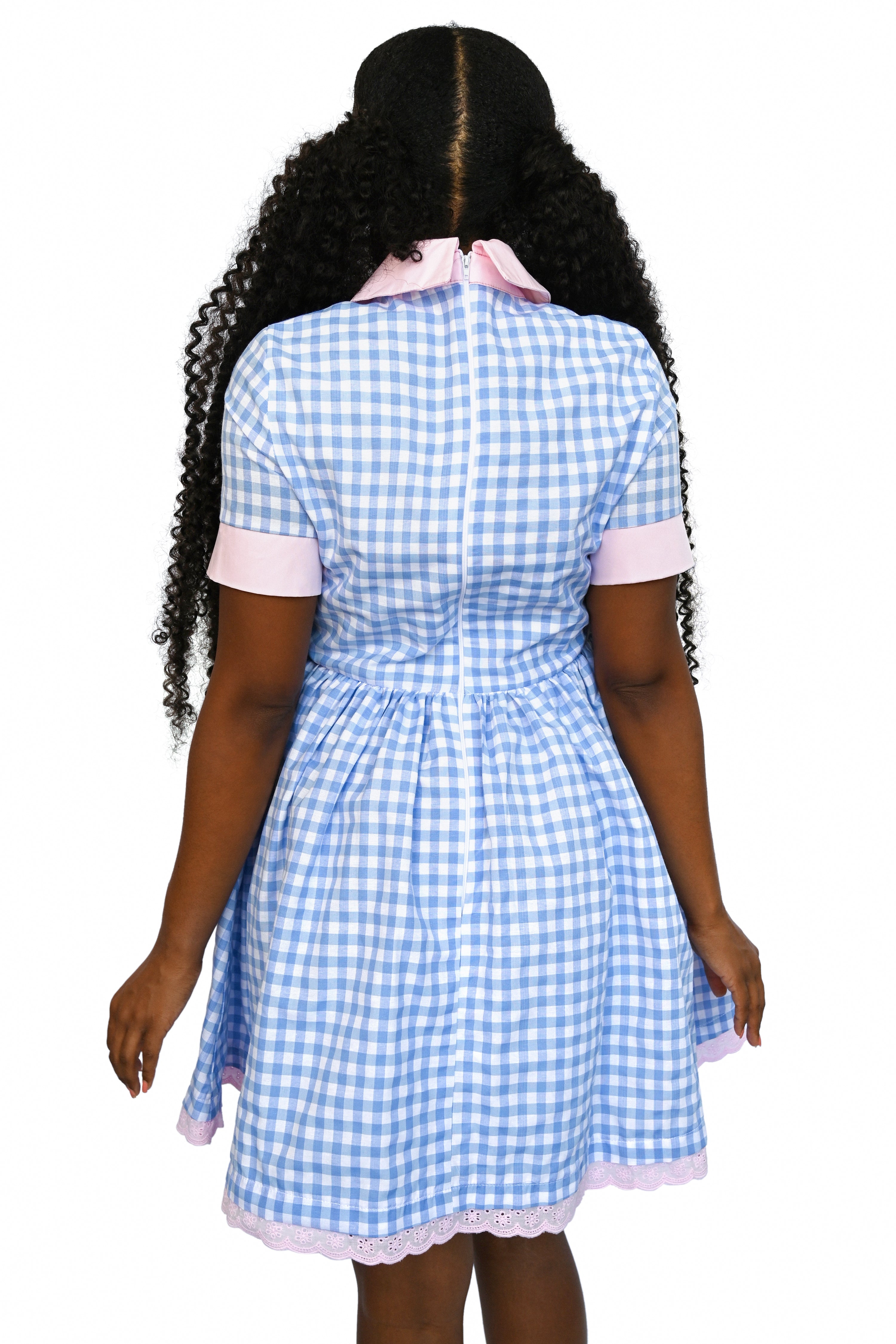 Knee length gingham dress with pink collar and trim, featuring a cute crying teddy bear graphic on the front