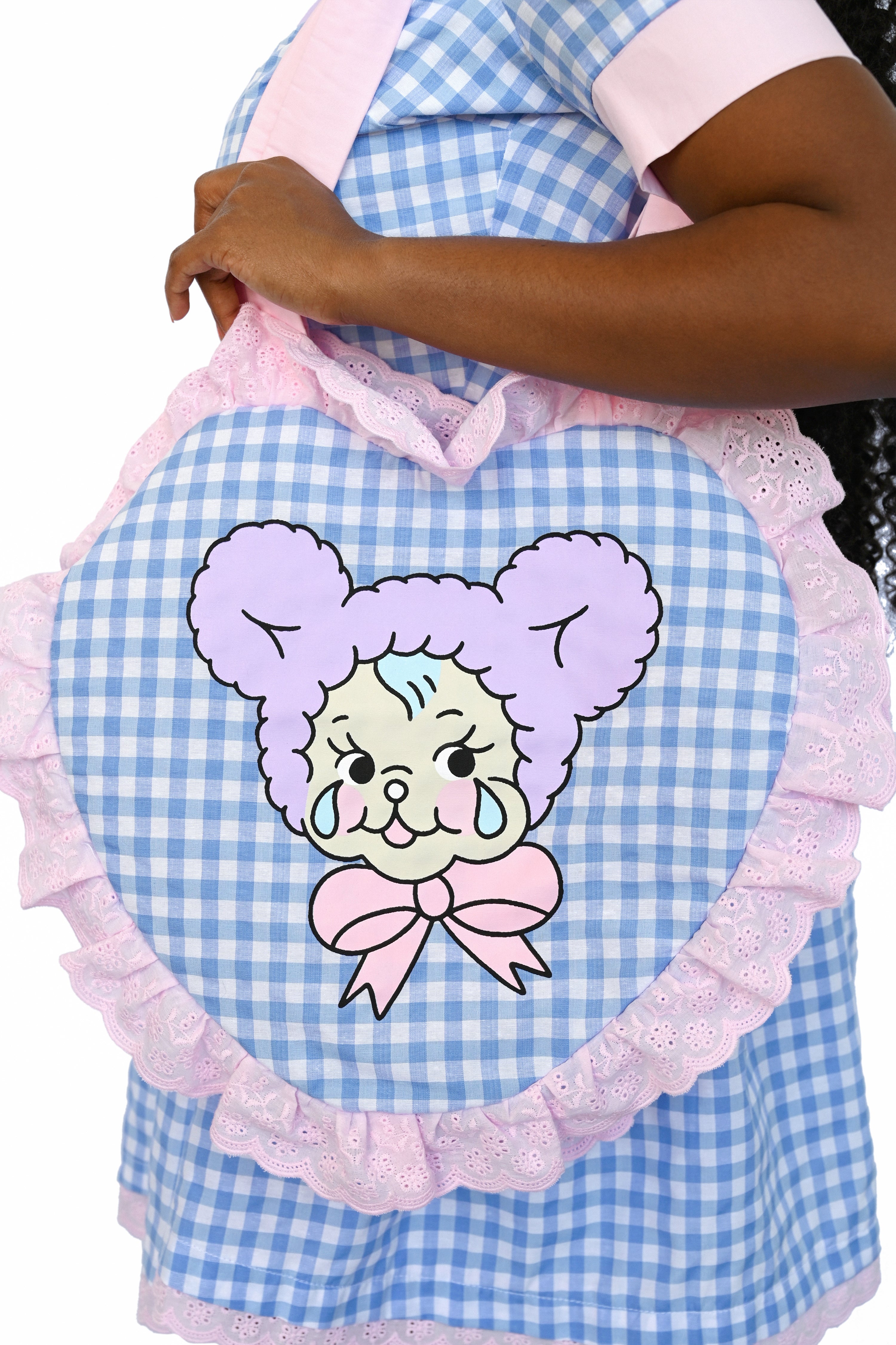 Blue gingham heart shaped bag with pink trim and hands, featuring a cute crying teddy bear graphic
