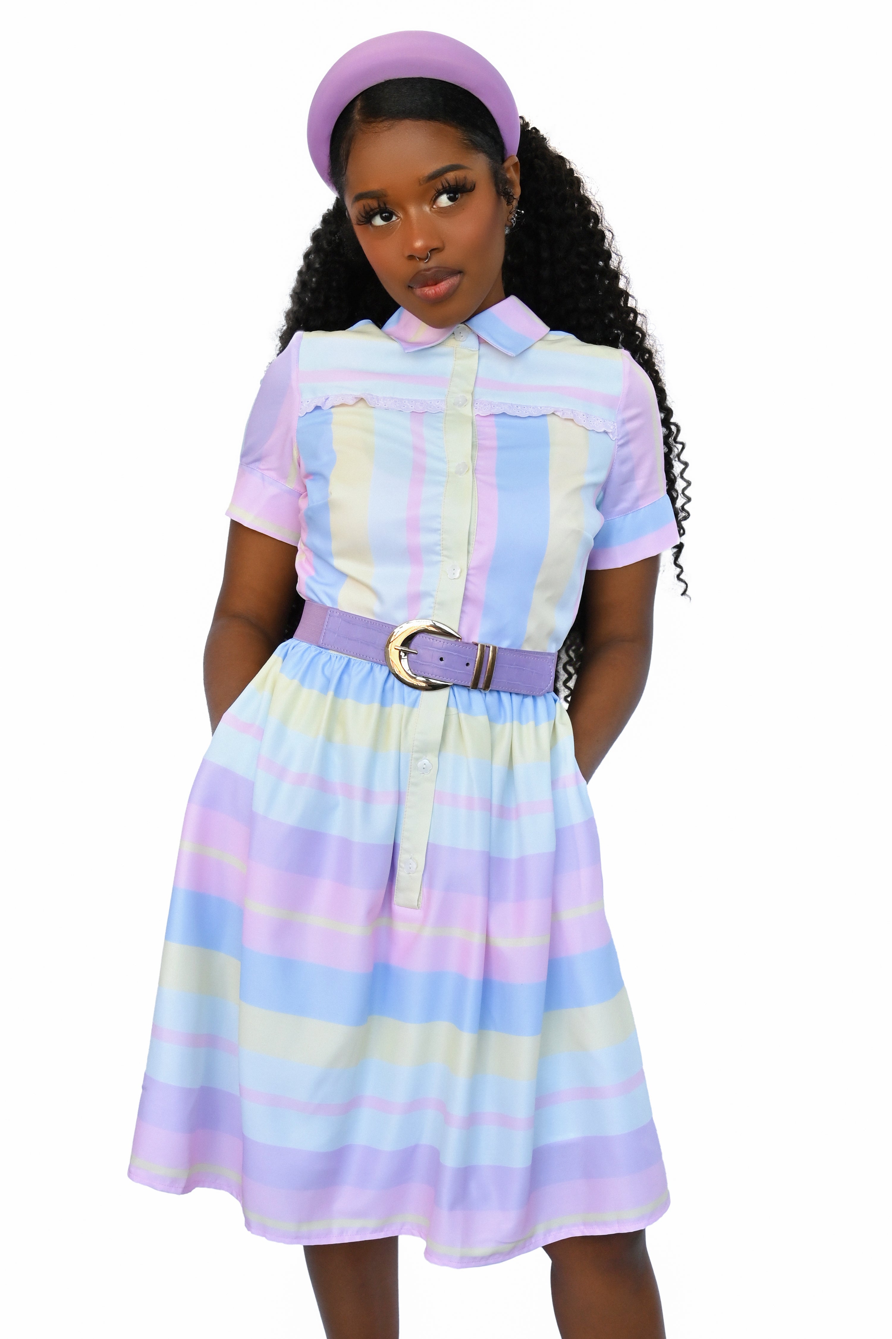 pastel striped button up dress with pointed collar, white flower buttons, and pink eyelet lace trim detail across the chest. Colours are: Pink, Purple, Light Blue, Yellow, Light Indigo. Vertical stripes on the top portion, horizontal on the lower half