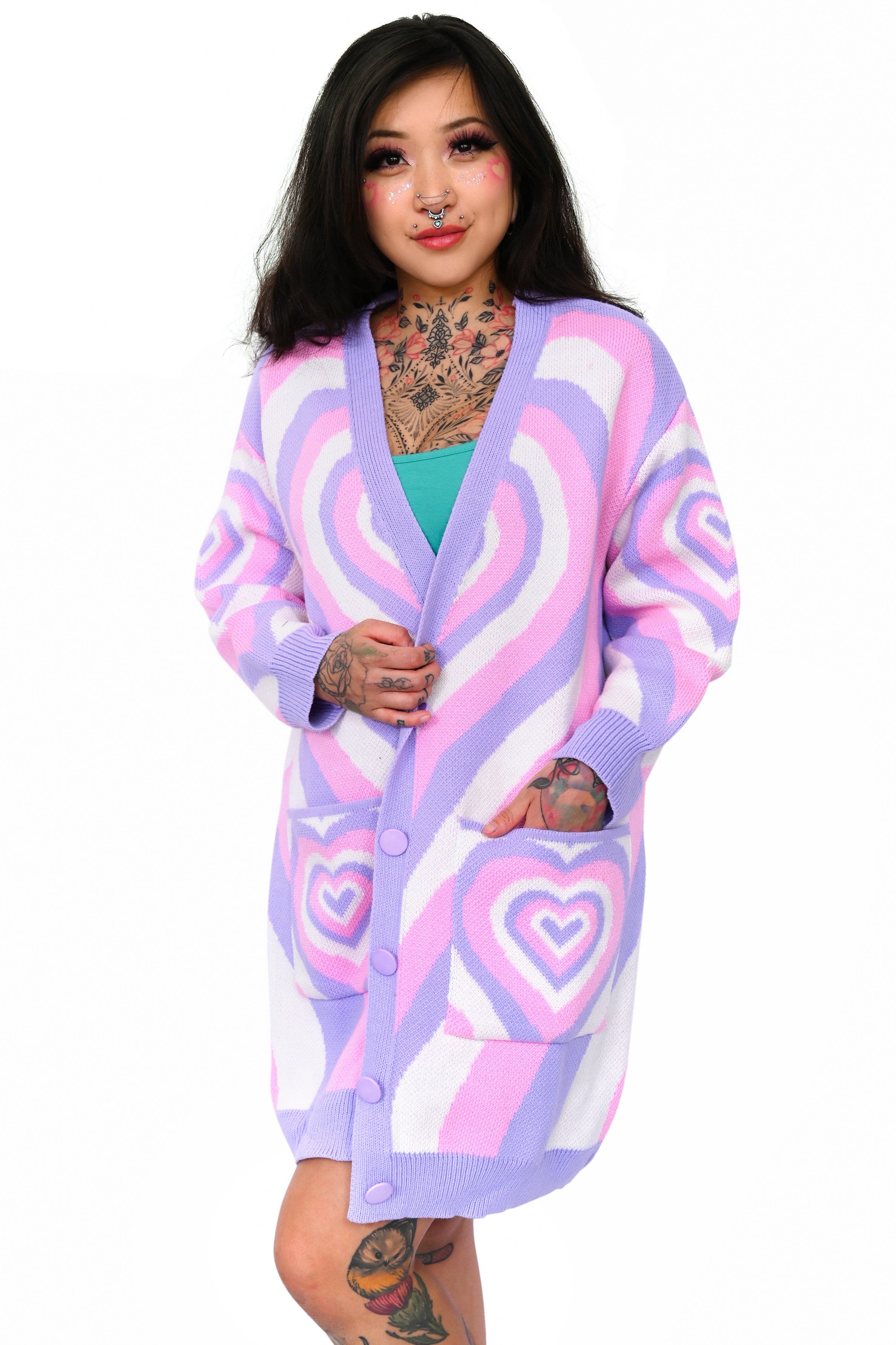 slouchy oversized statement sweater in Lavender, White, and purple with hearts all over shown on a standing XS model